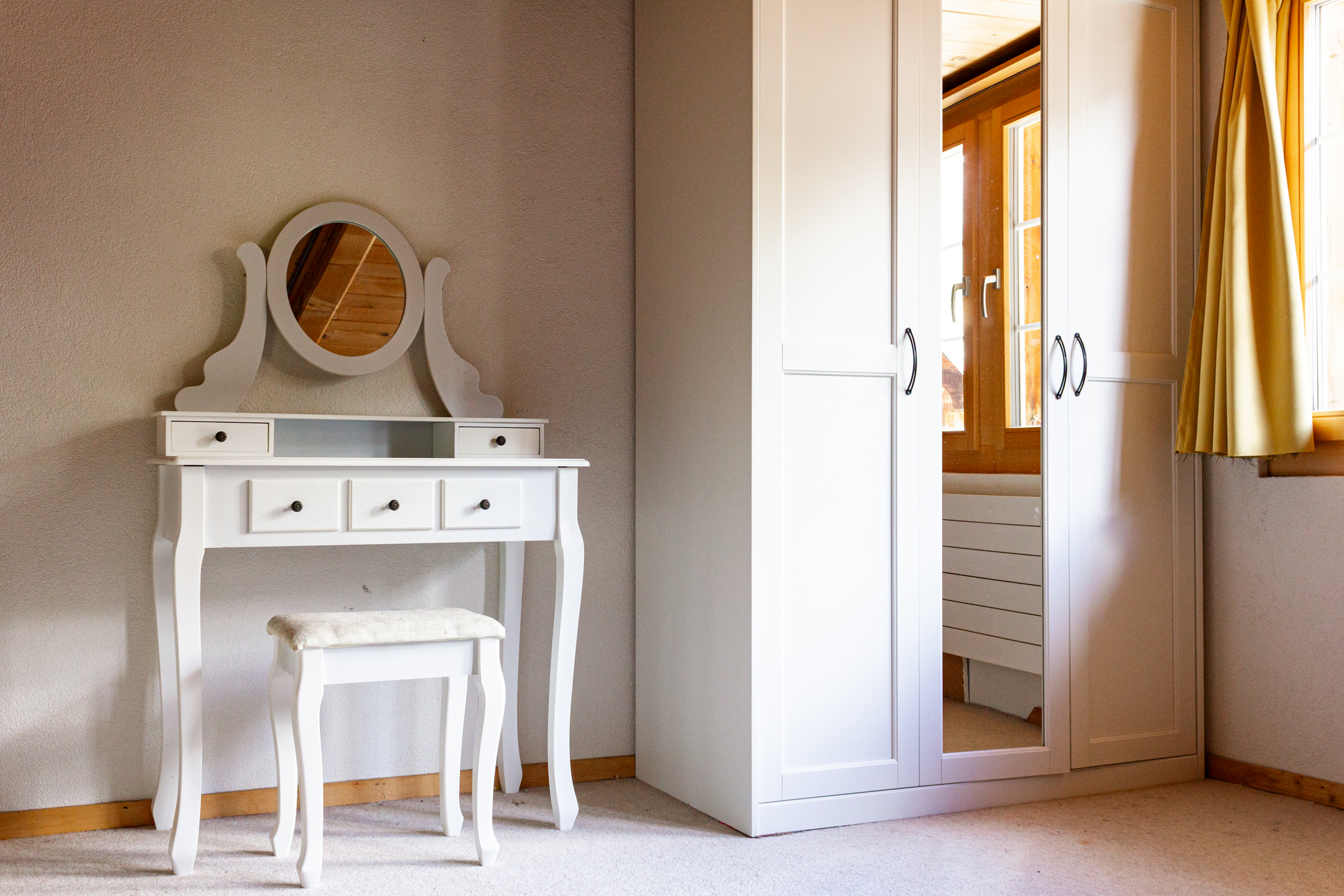 Helles Schlafzimmer mit Schminktisch und Kleiderschrank