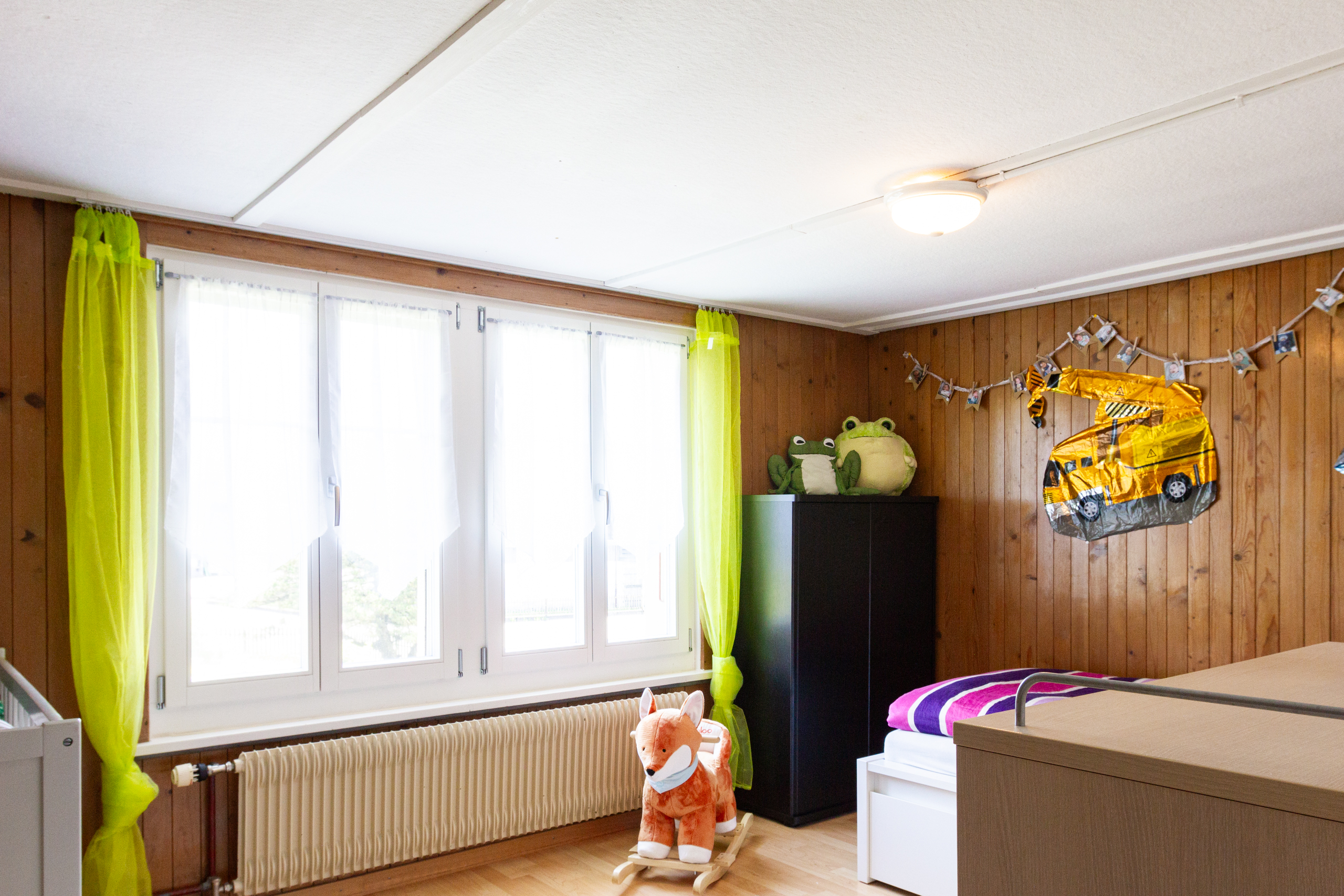 Kinderzimmer mit Holzvertäfelung und großem Fenster