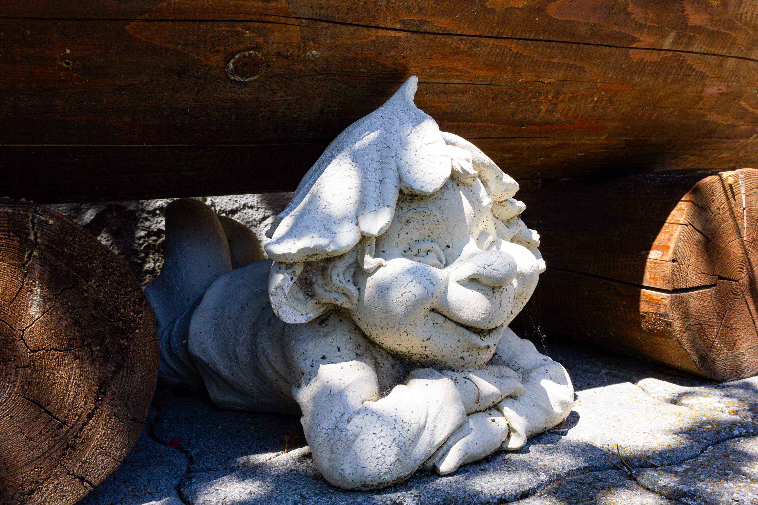 Gartenfigur unter Holzbank