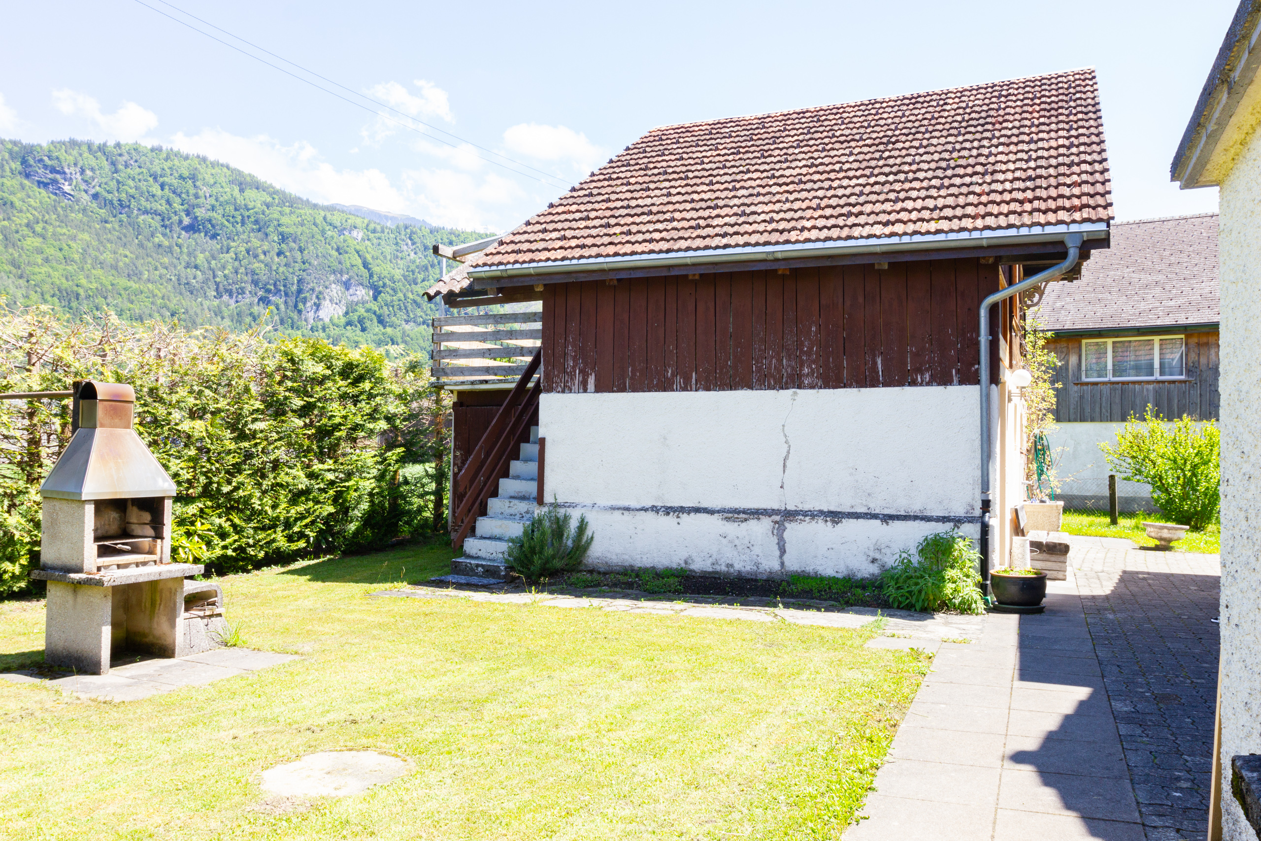 Außenansicht eines Hauses mit Garten und Bergkulisse