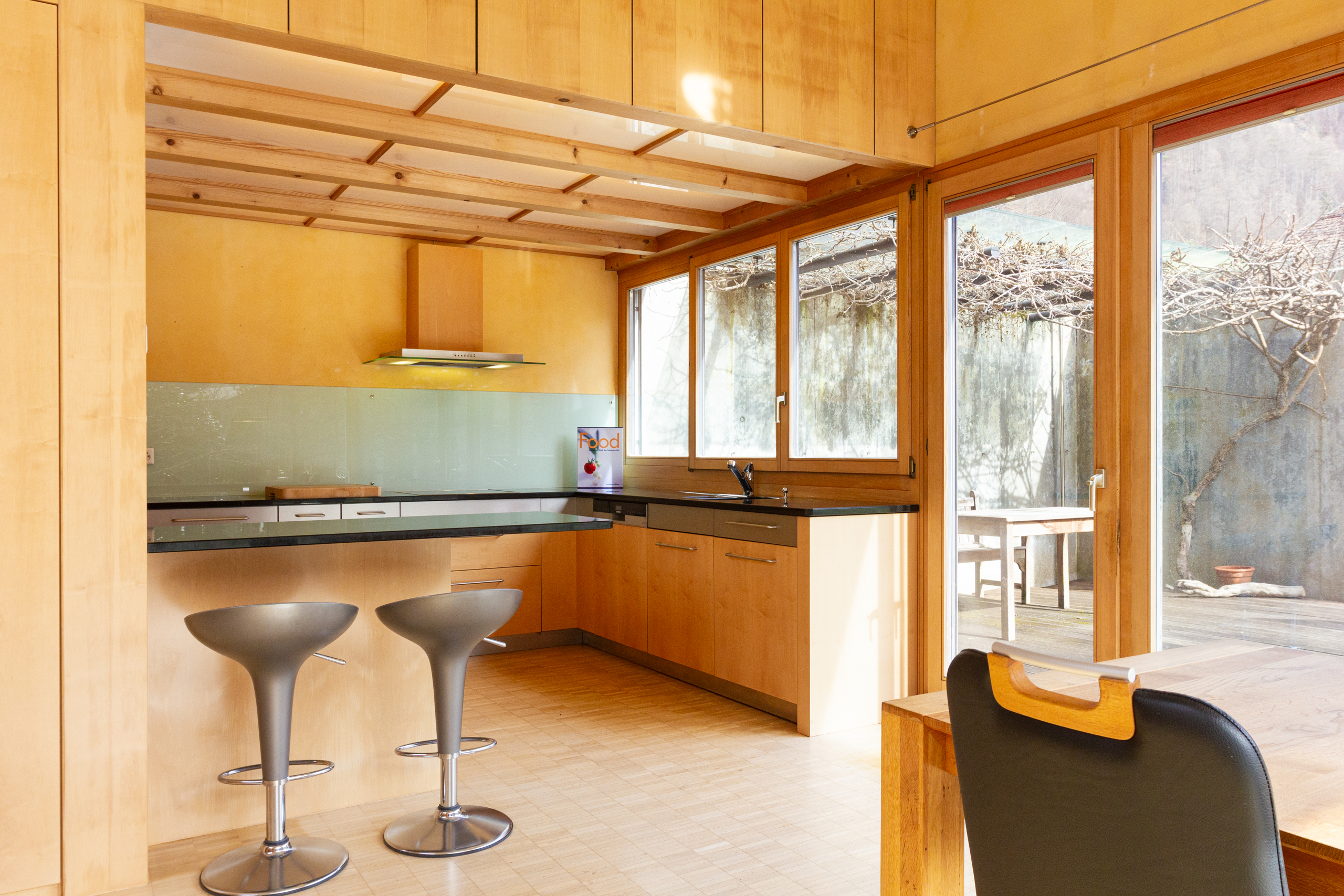 Helle Küche mit Holzoptik und Gartenblick