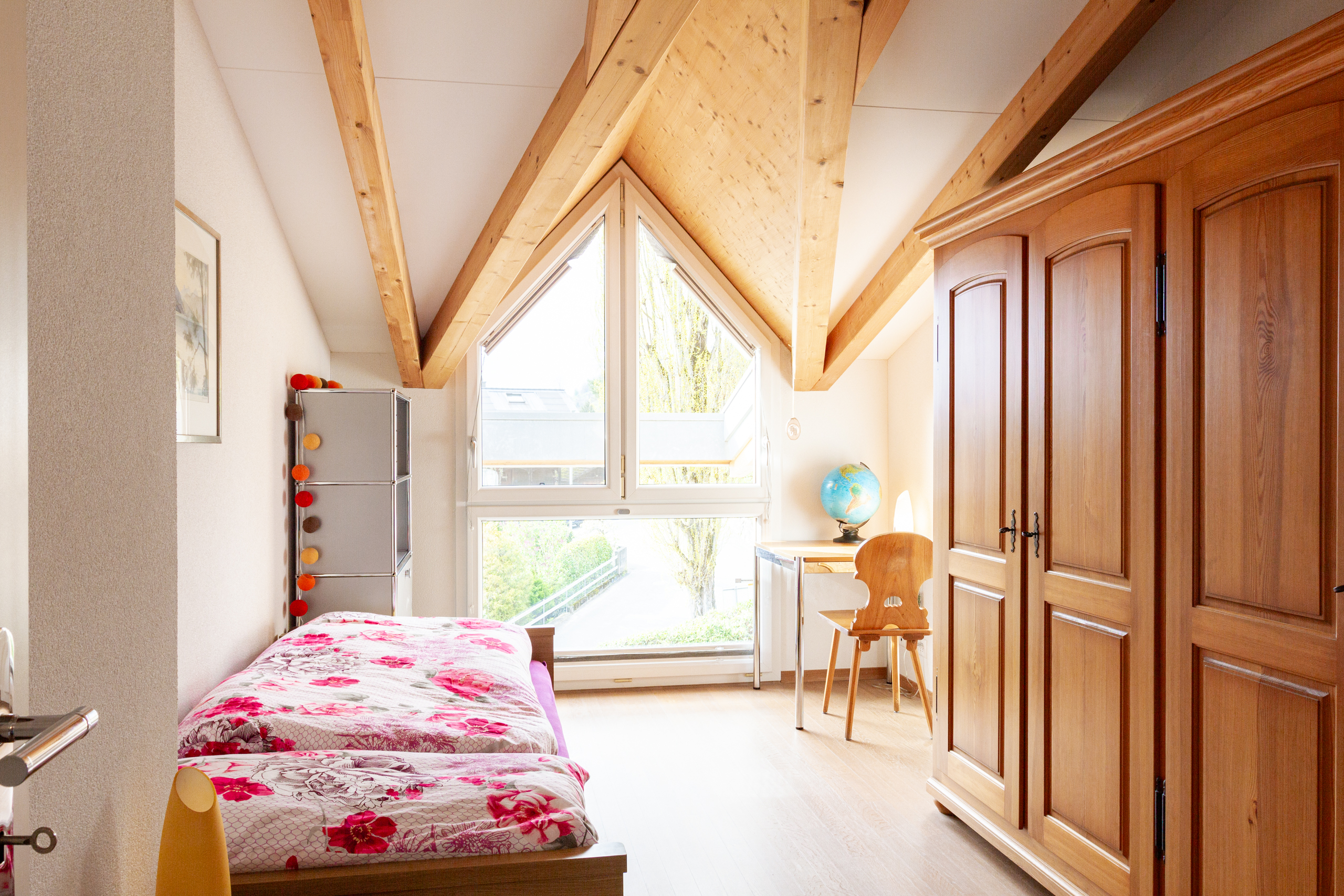 Dachzimmer mit Bett und Möbeln