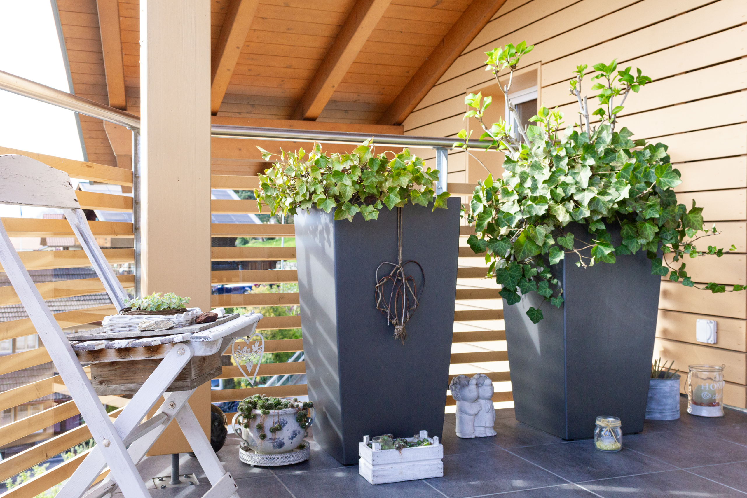 Gemütlicher Balkon mit Pflanzen und Holzverkleidung