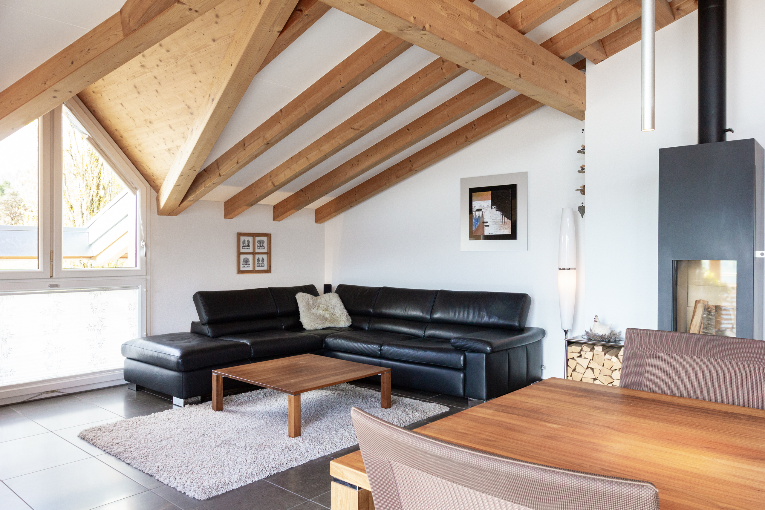 Wohnzimmer mit sichtbaren Holzbalken und Kamin