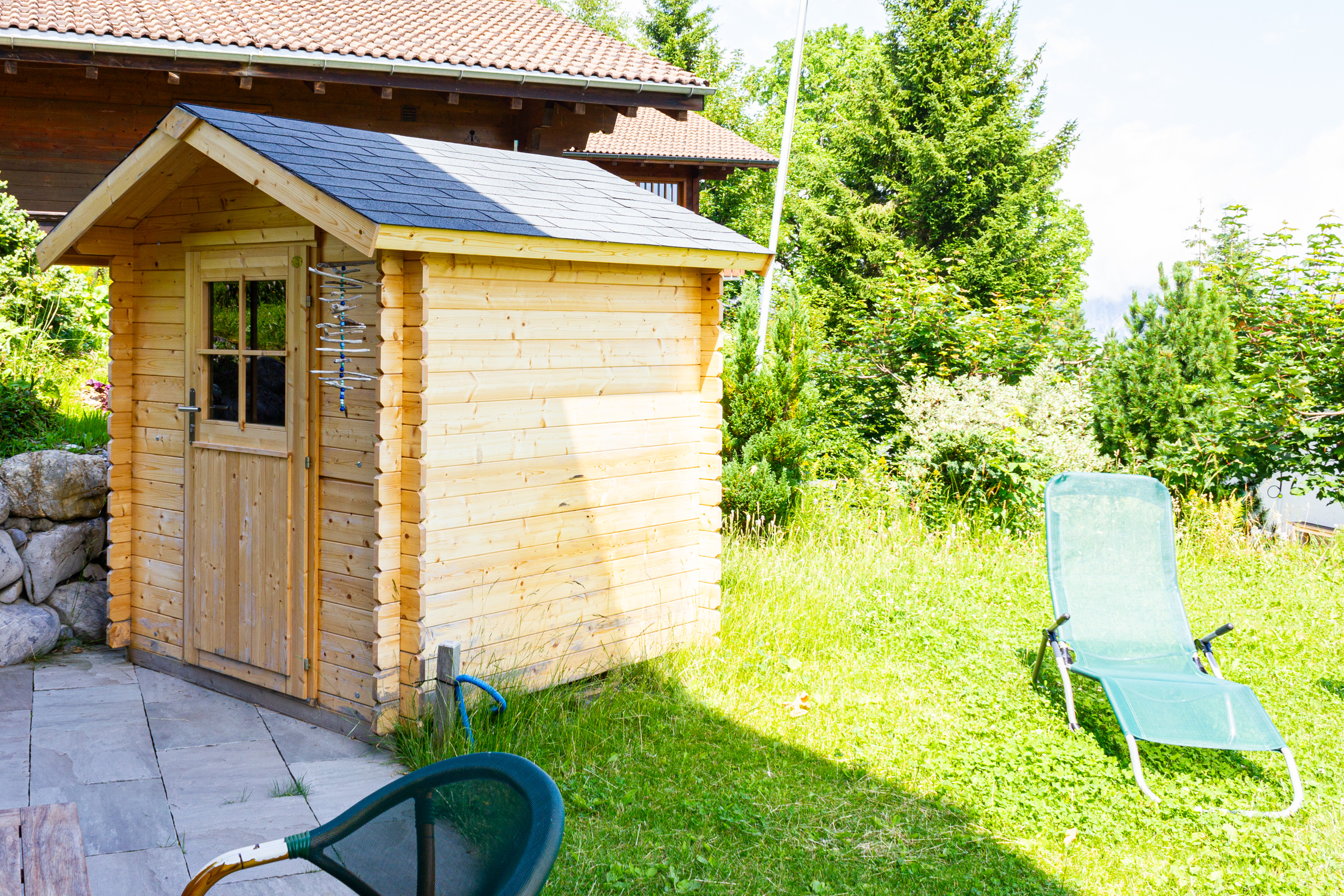 Holzgartenhaus im sonnigen Garten