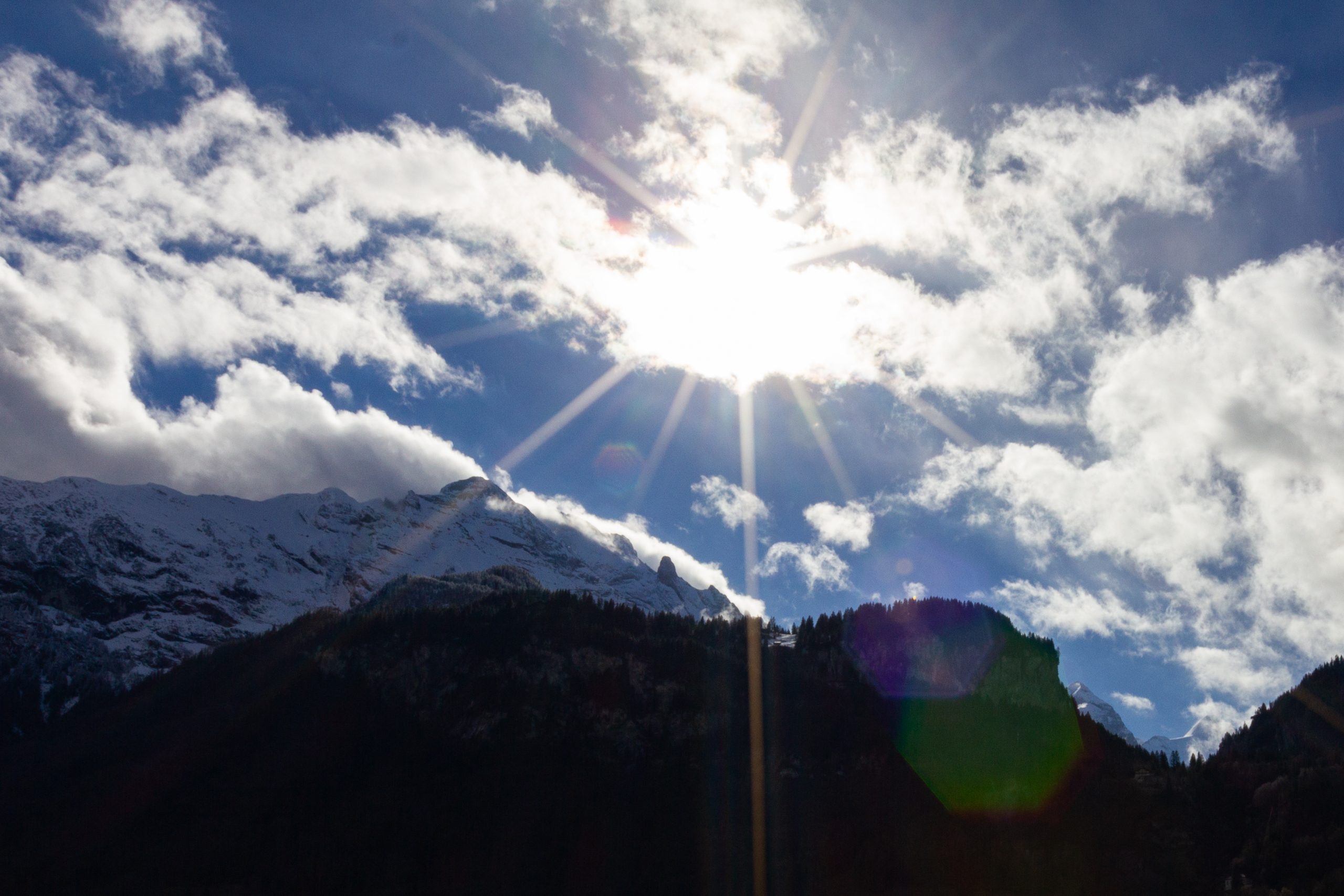 Bergblick mit Sonne und Wolken