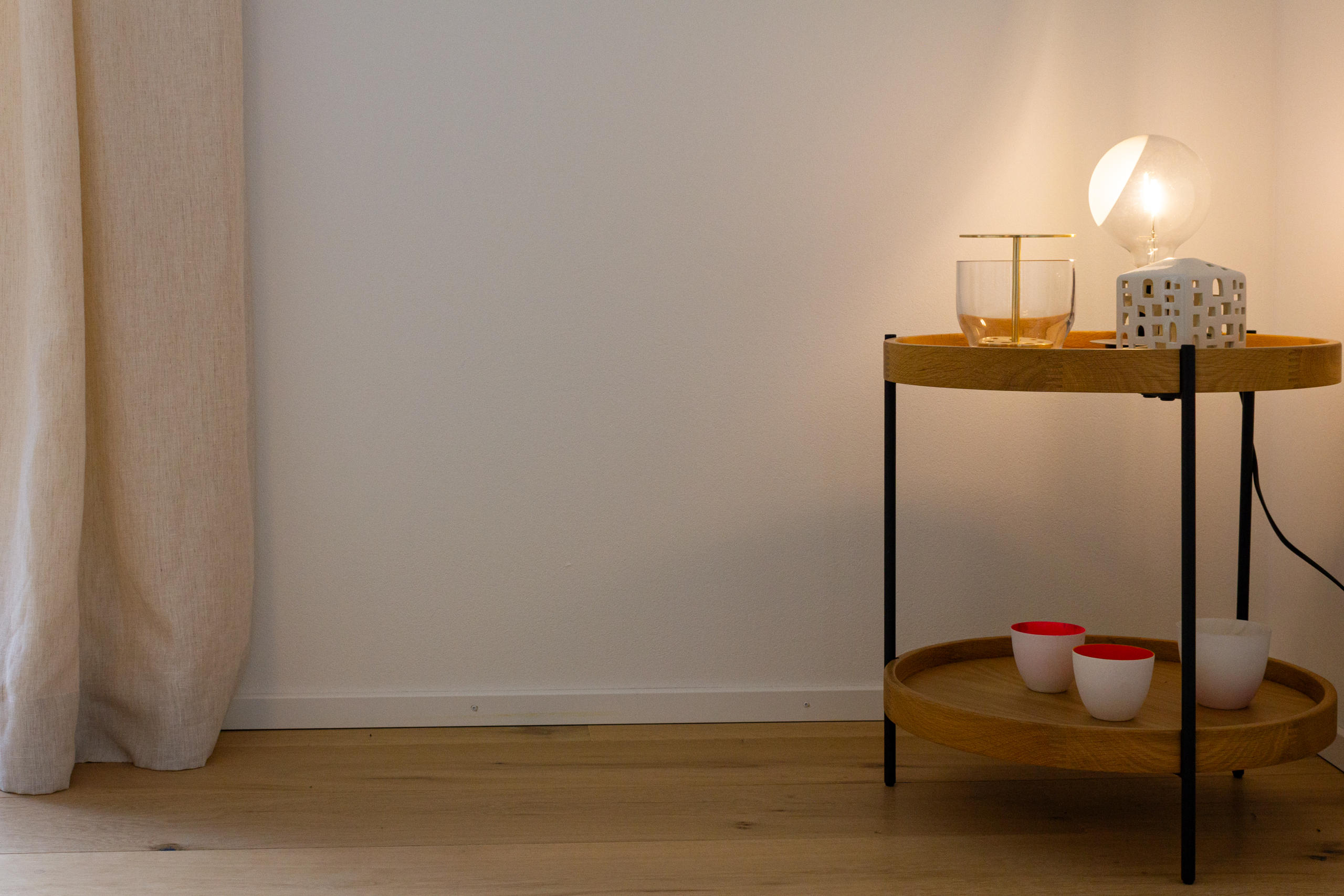Minimalistisch eingerichteter Innenraum mit Beistelltisch und Lampe
