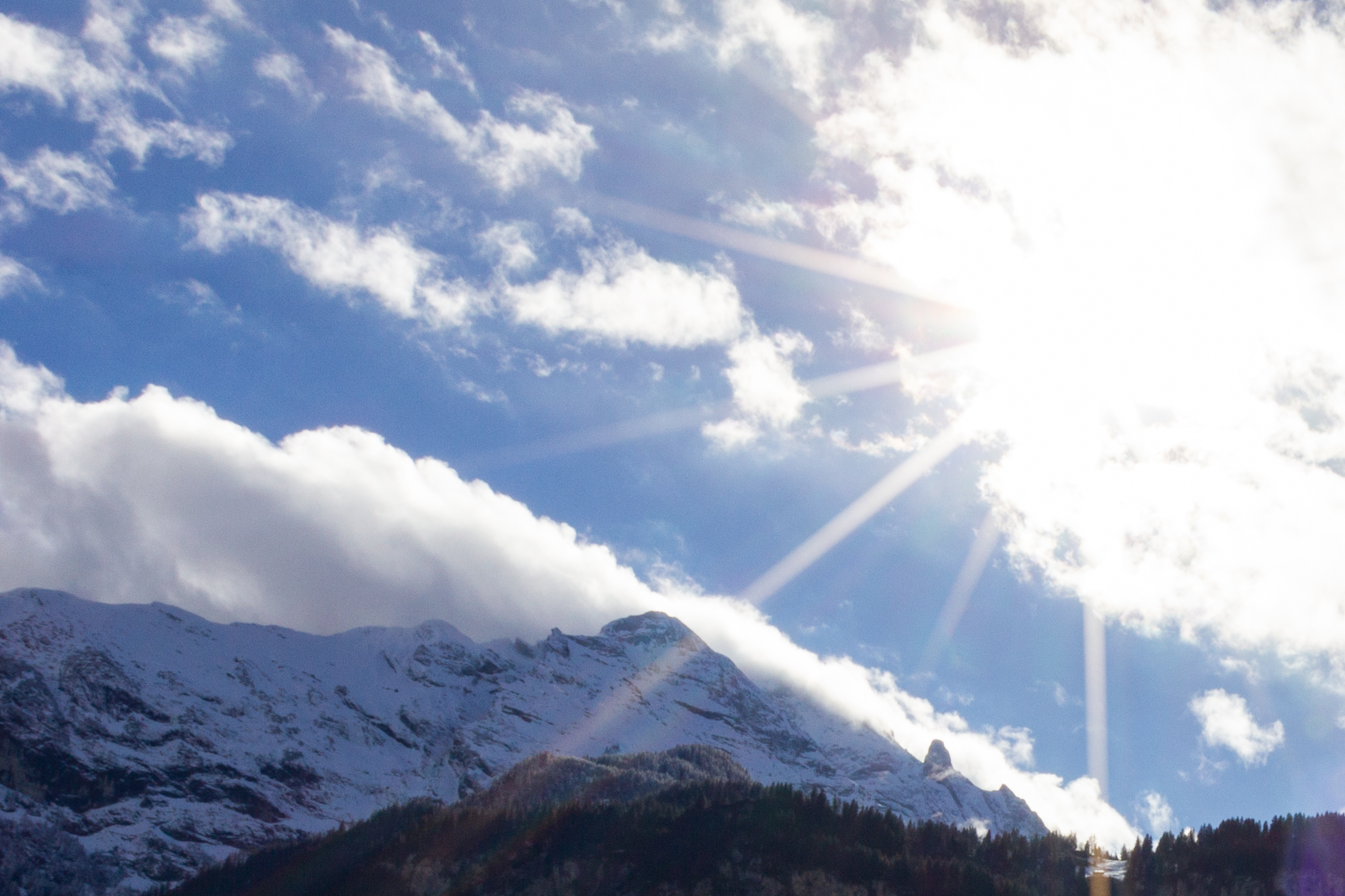 Berglandschaft mit Sonne und Wolken