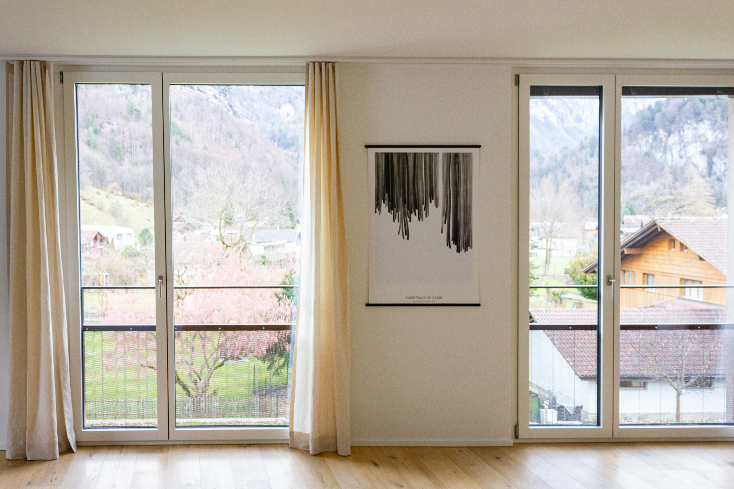 Heller Wohnraum mit großen Fenstern und Bergblick