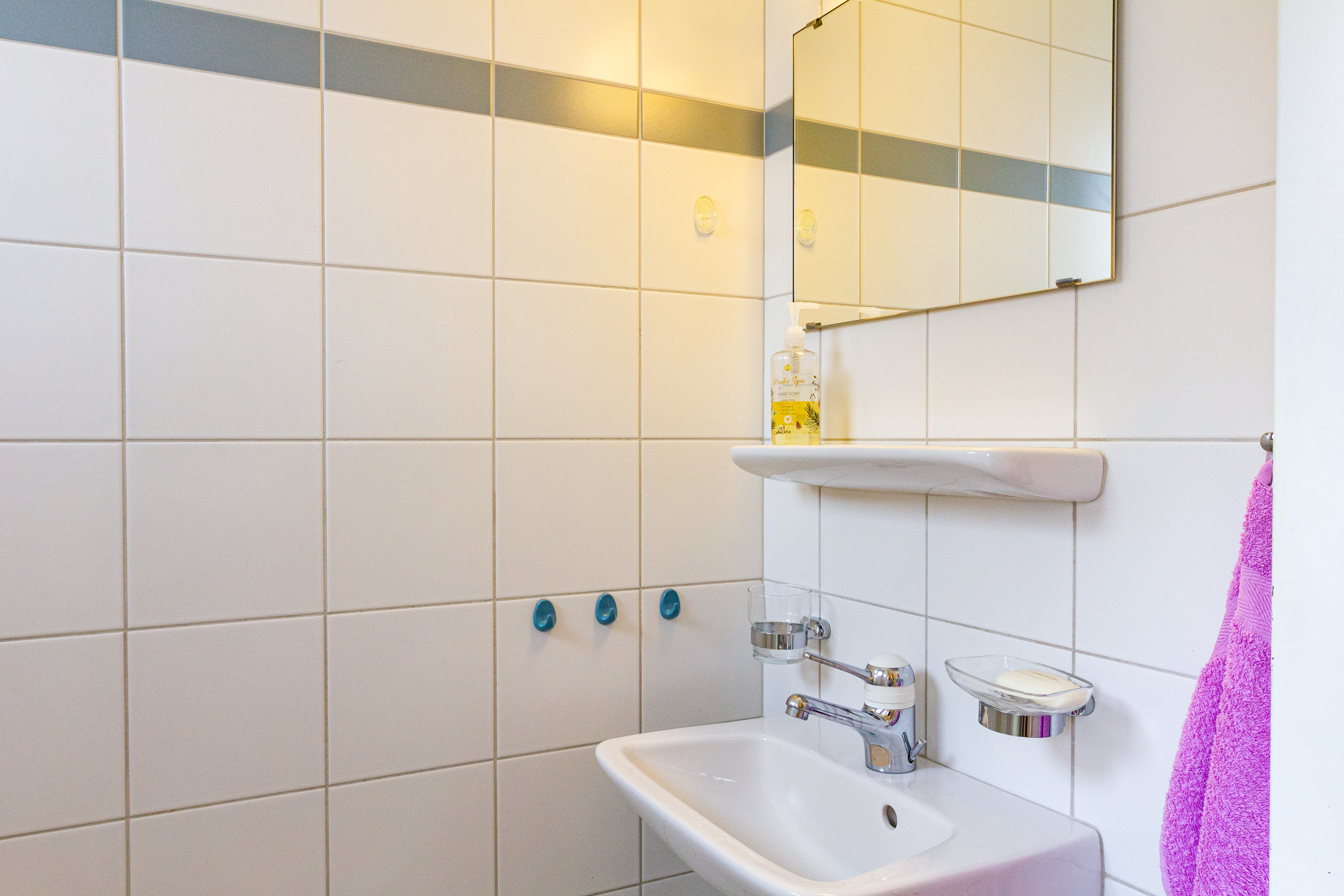 Kleines Bad mit Waschbecken und Spiegel