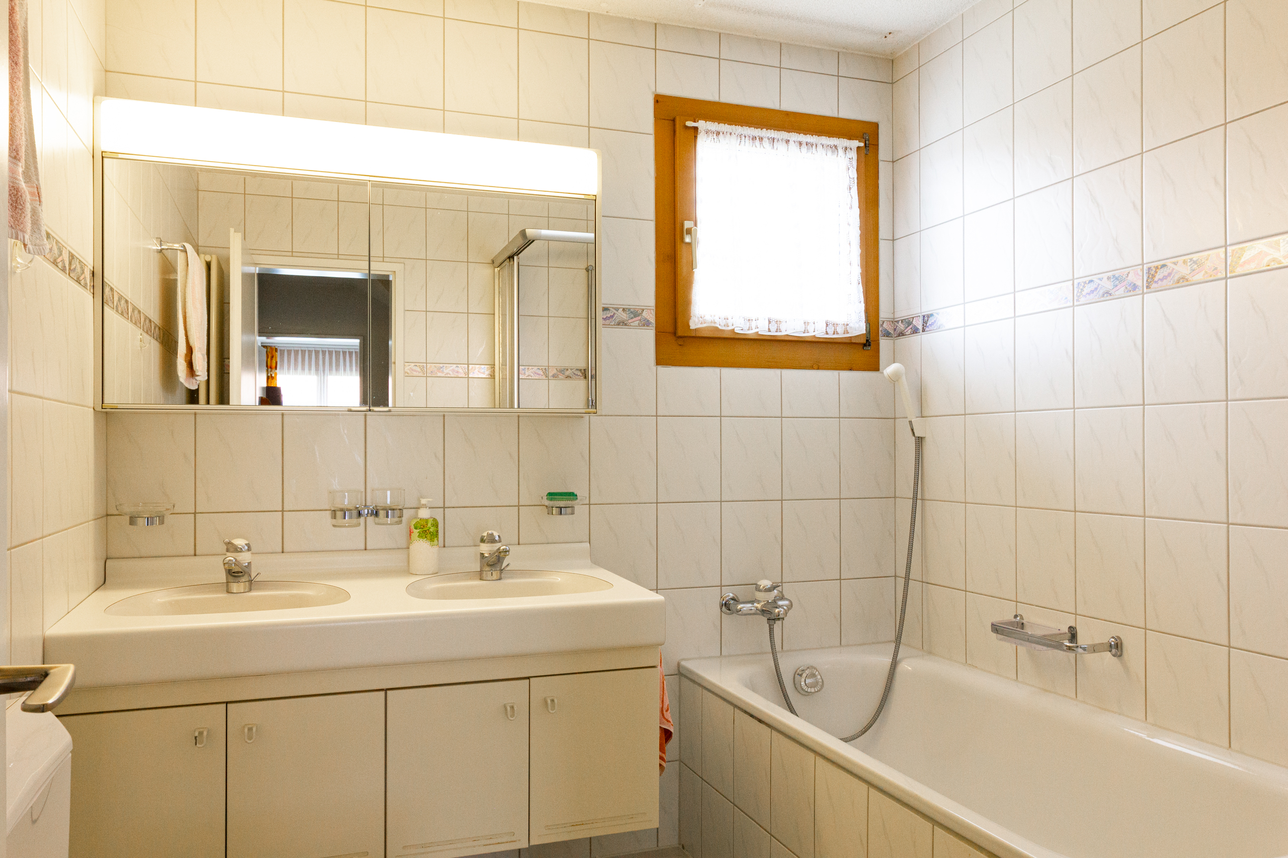 Badezimmer mit Badewanne und Doppelwaschbecken