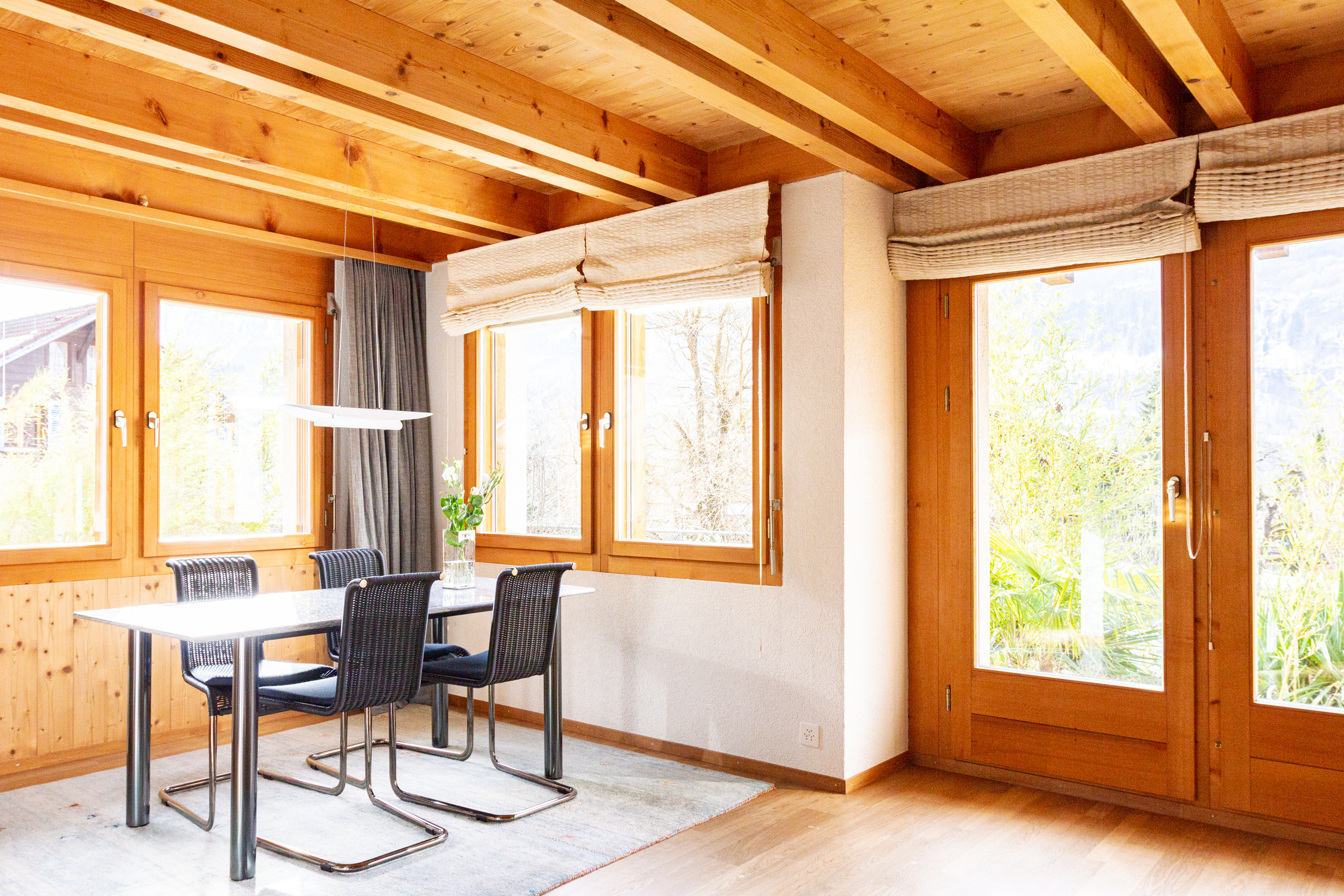 Heller Essbereich mit Holzdecke und großen Fenstern