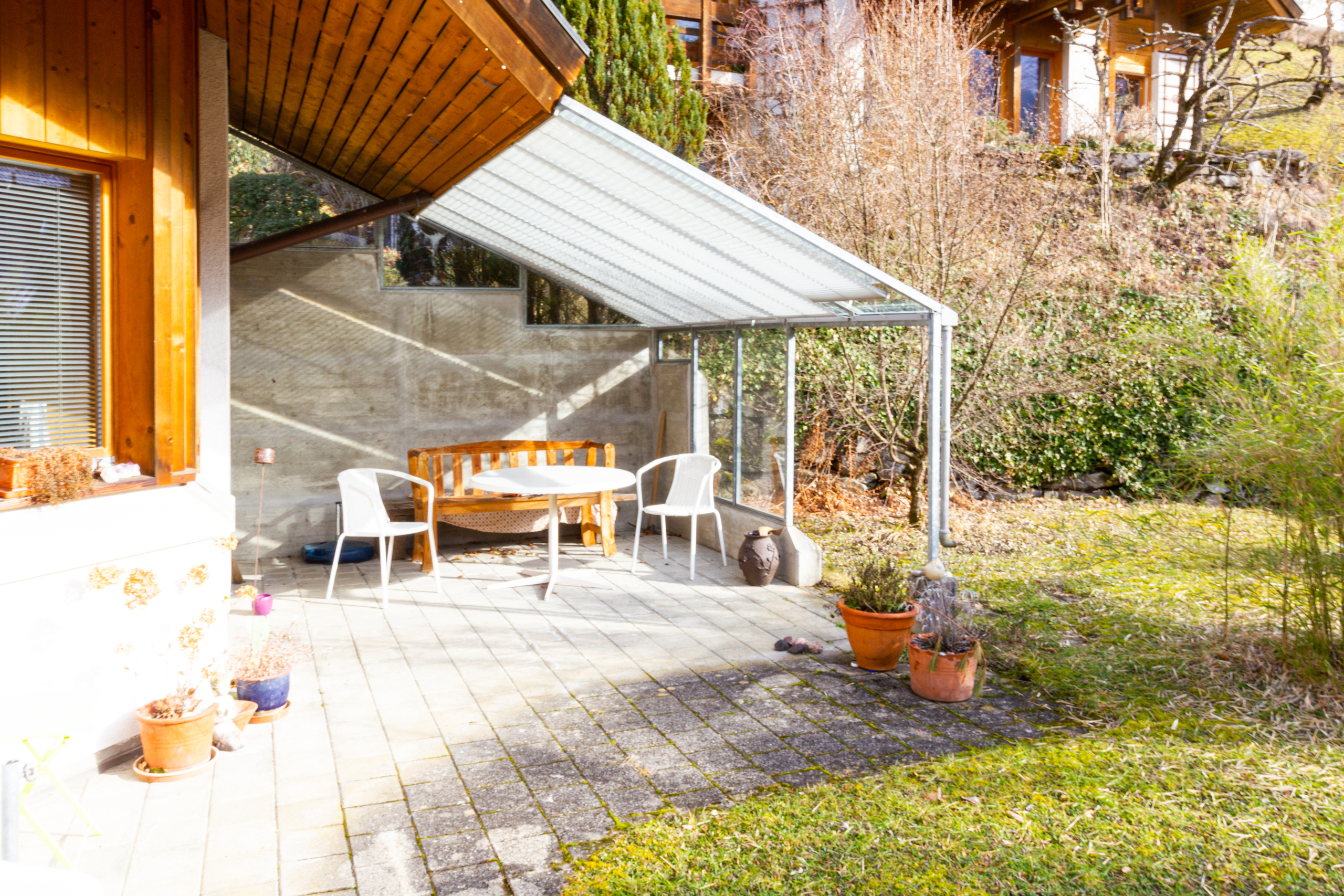 Überdachte Terrasse mit Gartenblick