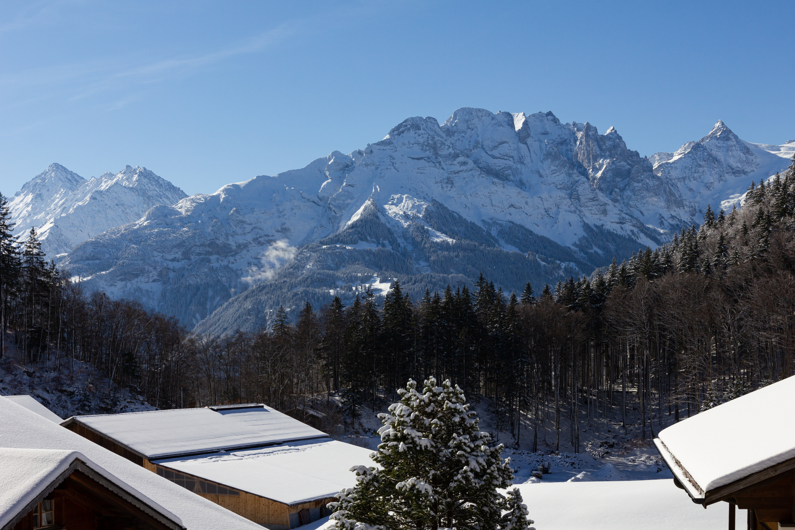 Schneebedeckte Berglandschaft mit Tal und Gebäudedächern