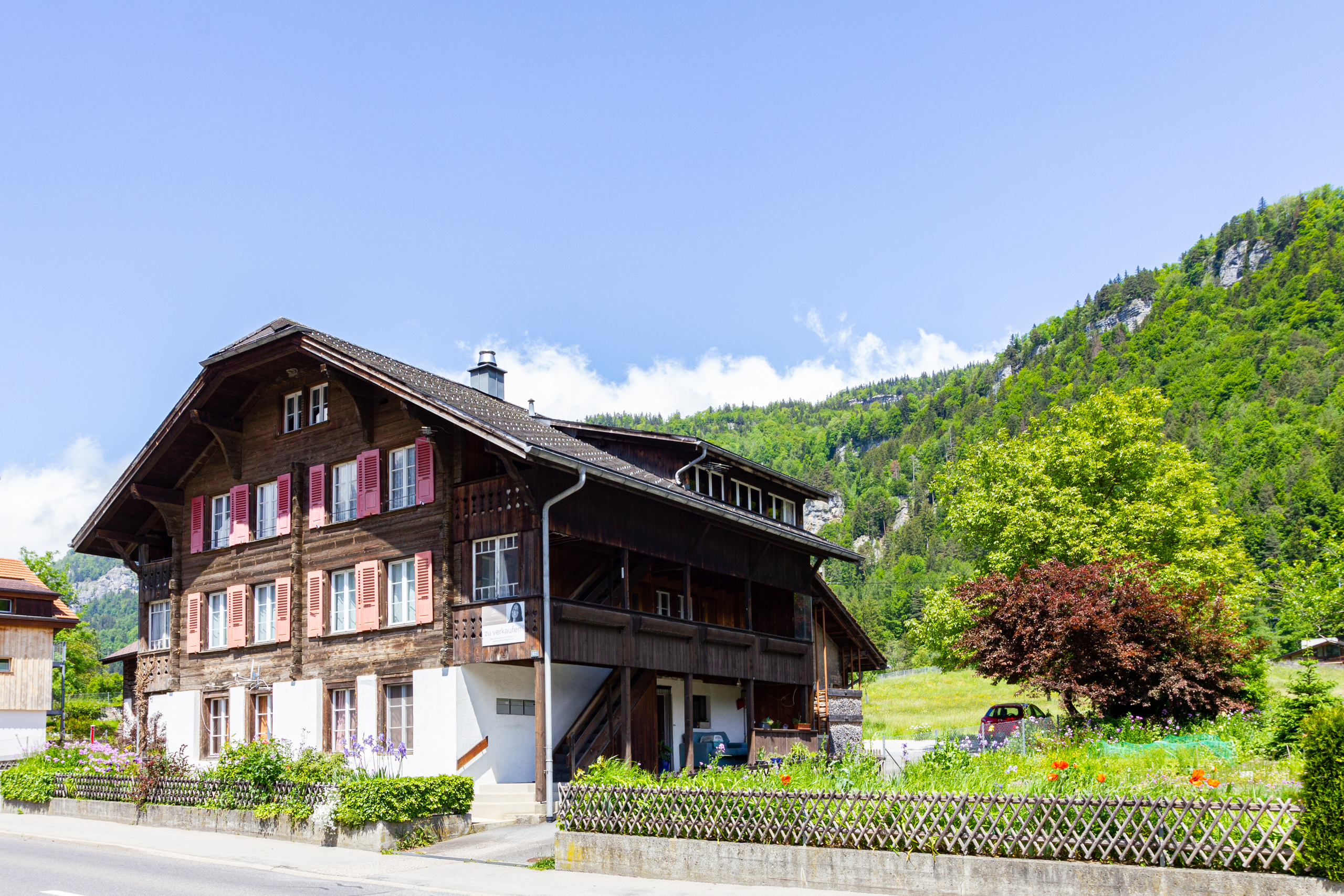 Alpines Holzhaus mit Garten und Bergkulisse