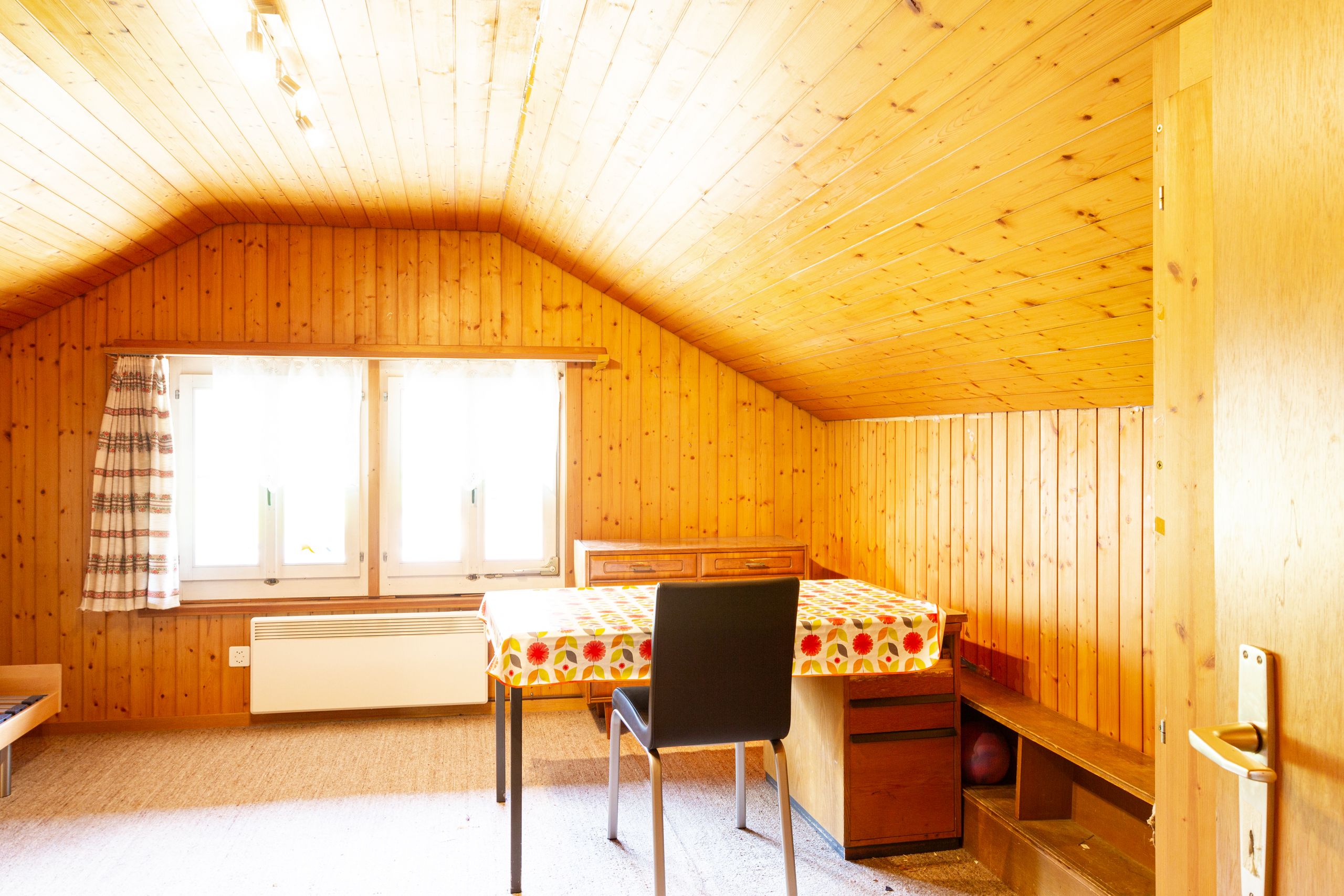 Holzvertäligtes Dachzimmer mit Tisch und Stühlen