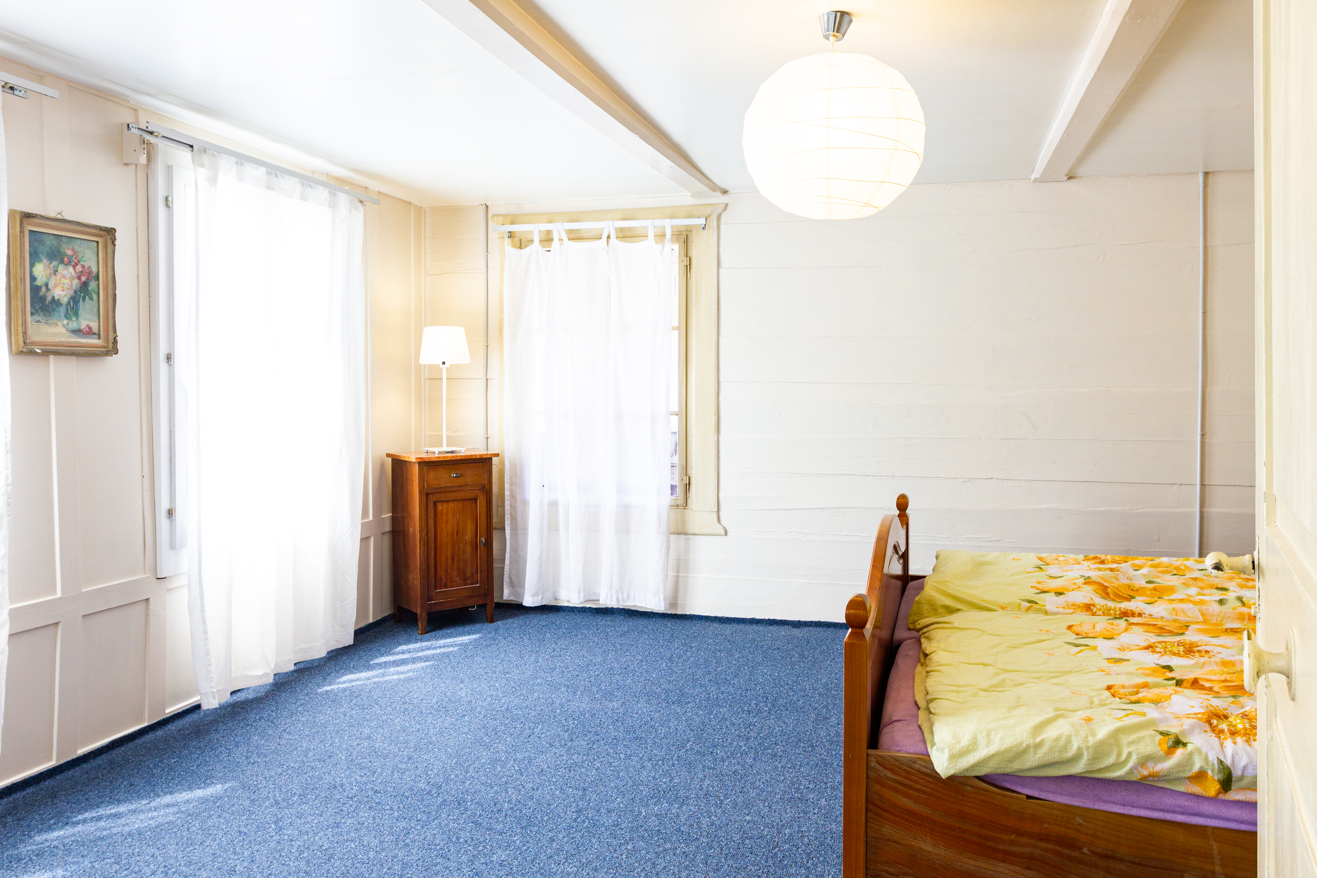 Helles Schlafzimmer mit blauem Teppich