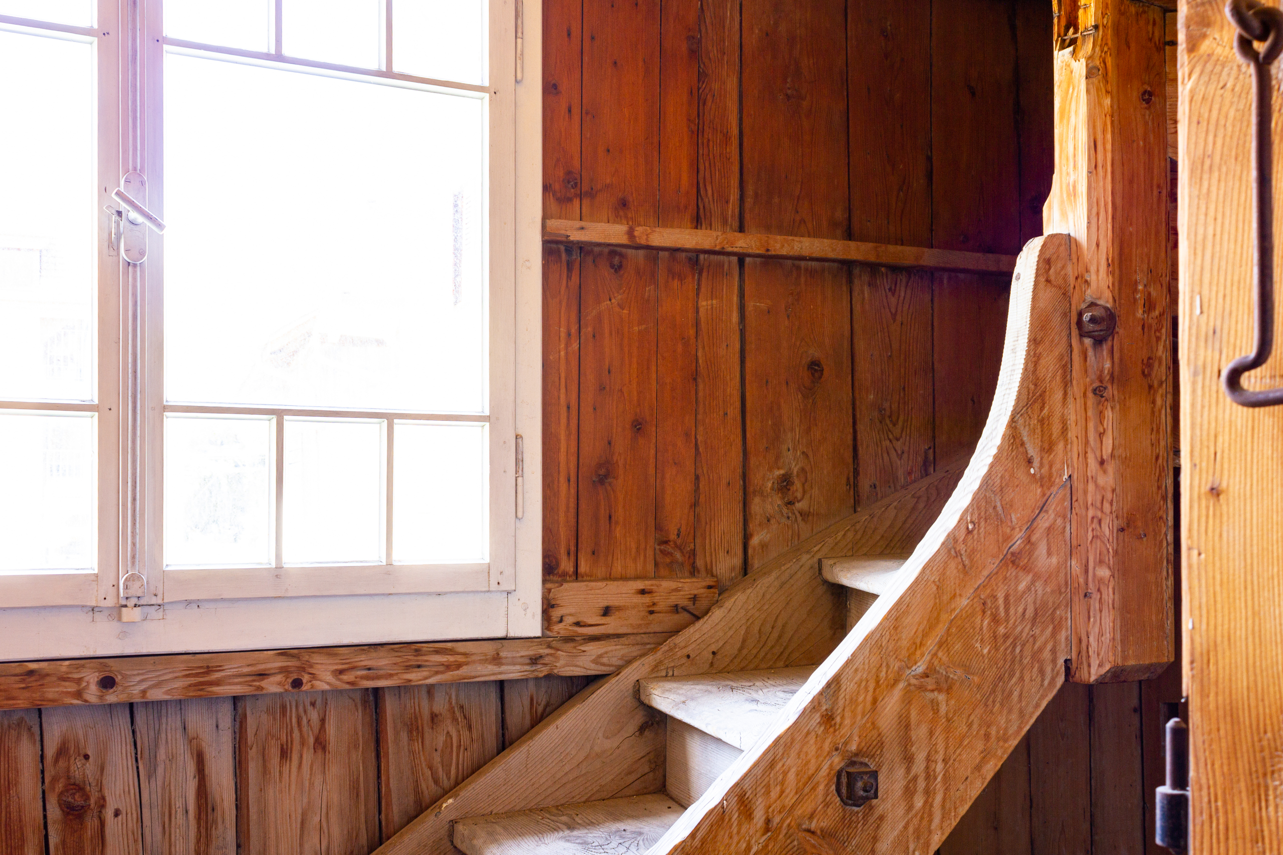 Rustikale Holztreppe neben hellem Fenster