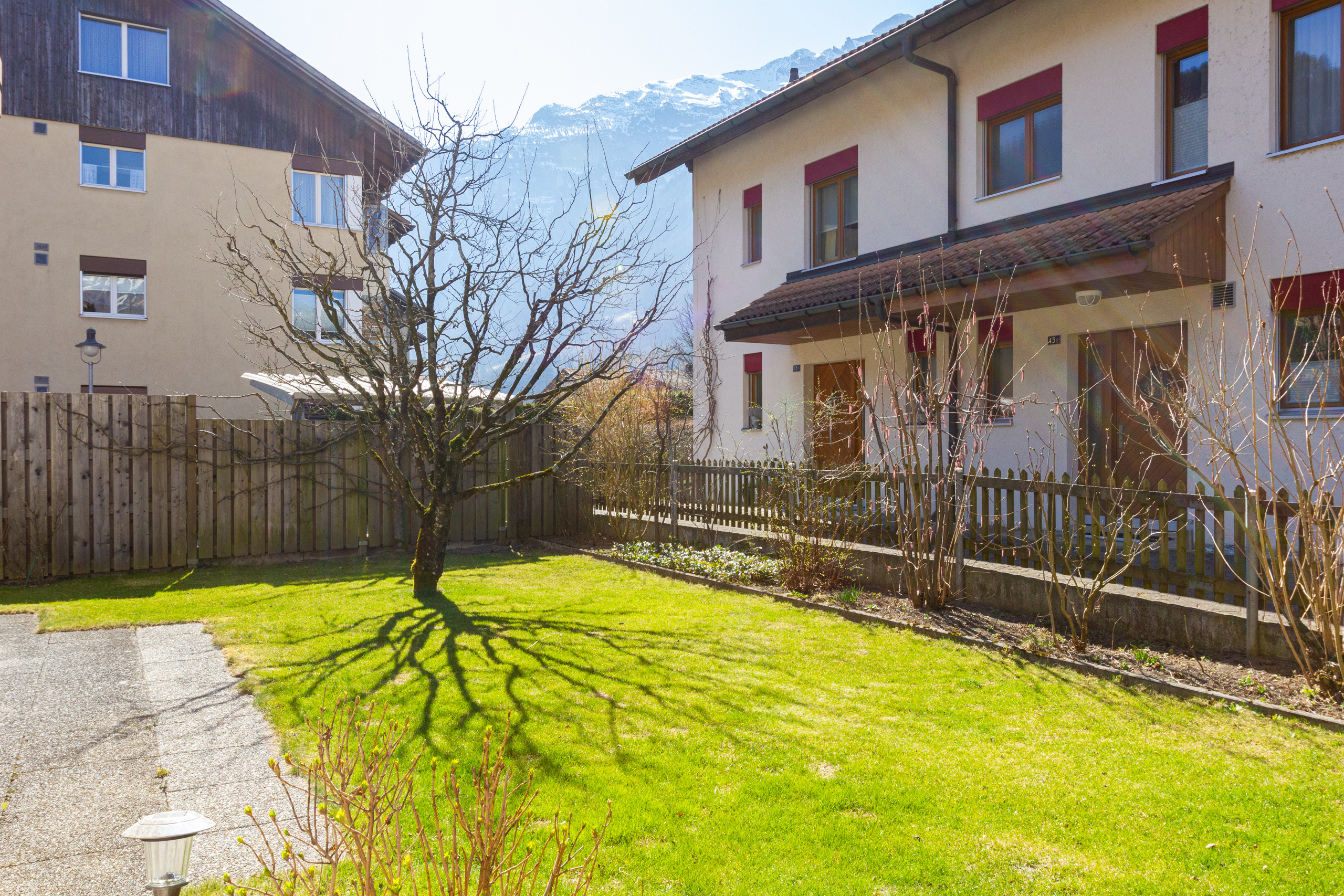 Gartenansicht eines Wohngebäudes mit Bergkulisse