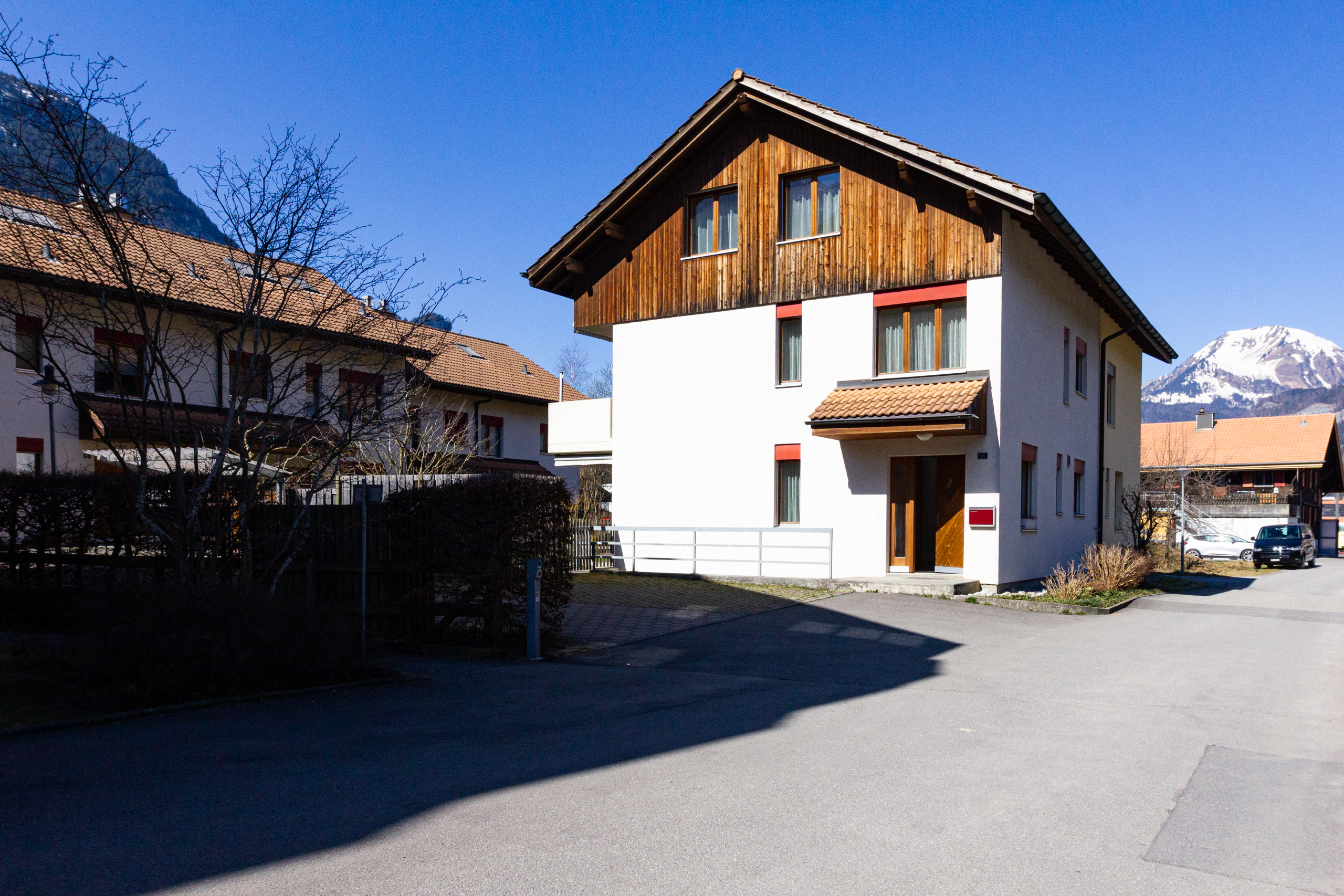 Doppelhaushälfte mit Holzgiebel und Bergkulisse