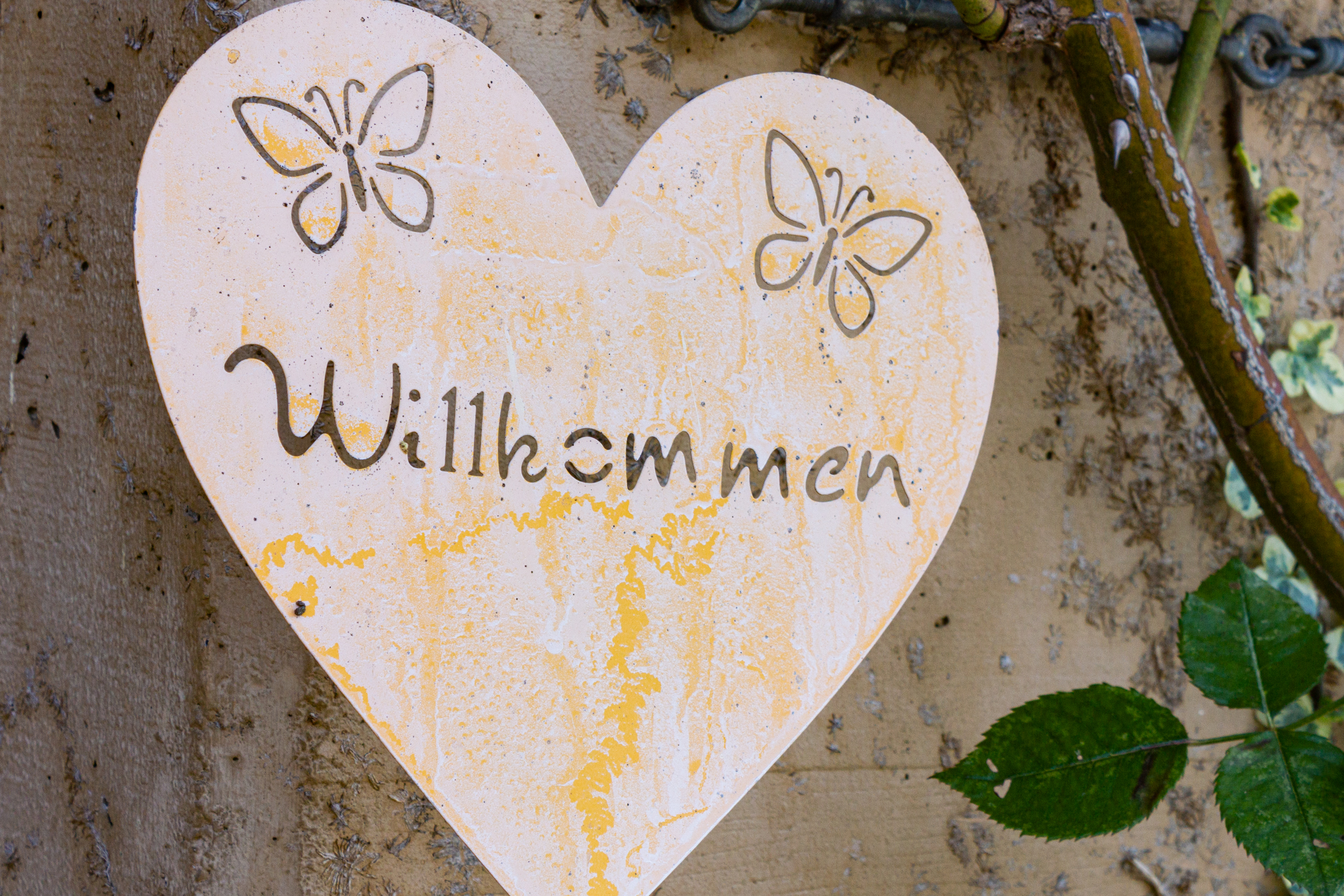 Herzförmiges Willkommensschild mit Blumenmotiv
