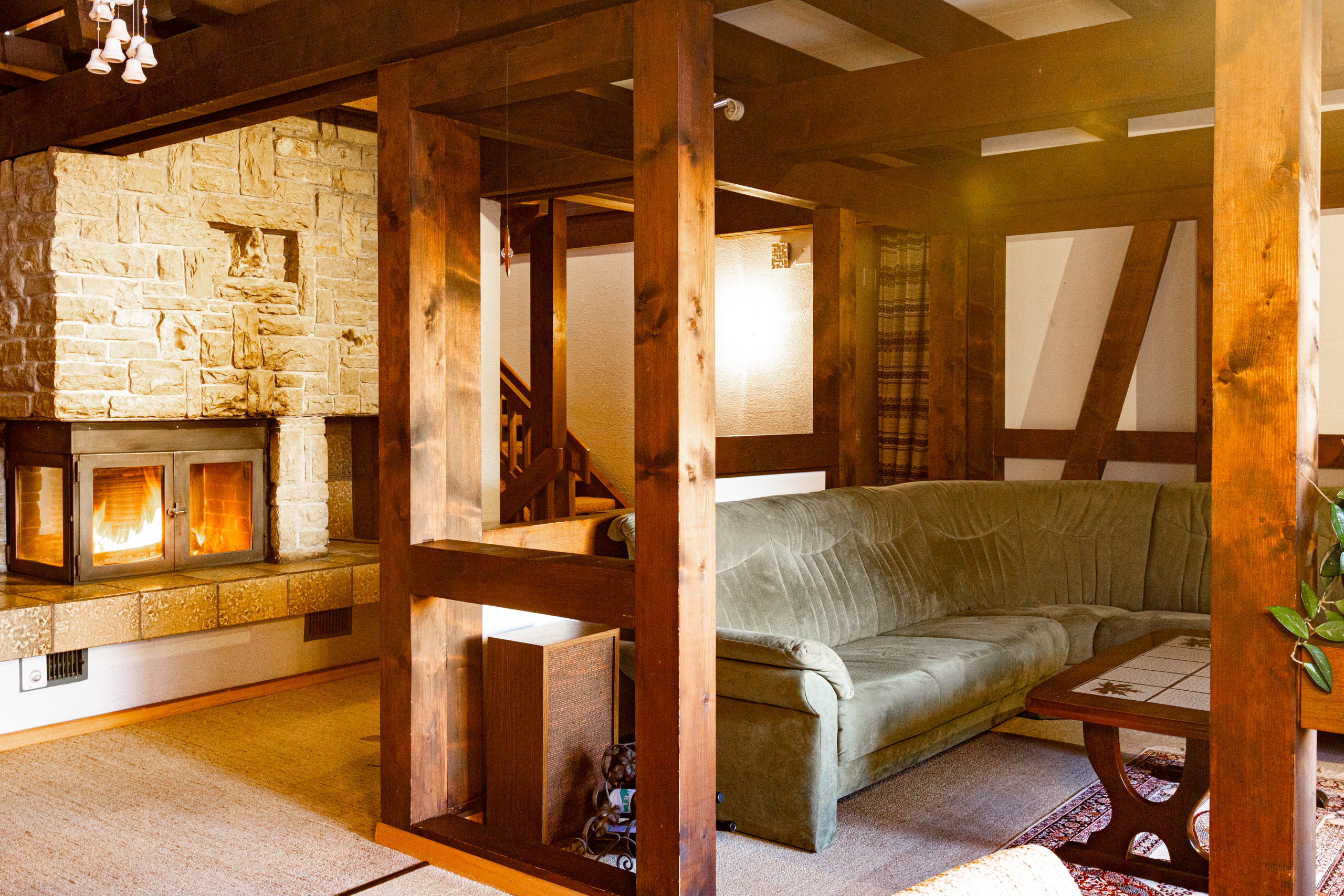 Gemütliches Wohnzimmer mit Kamin und Holztragwerk