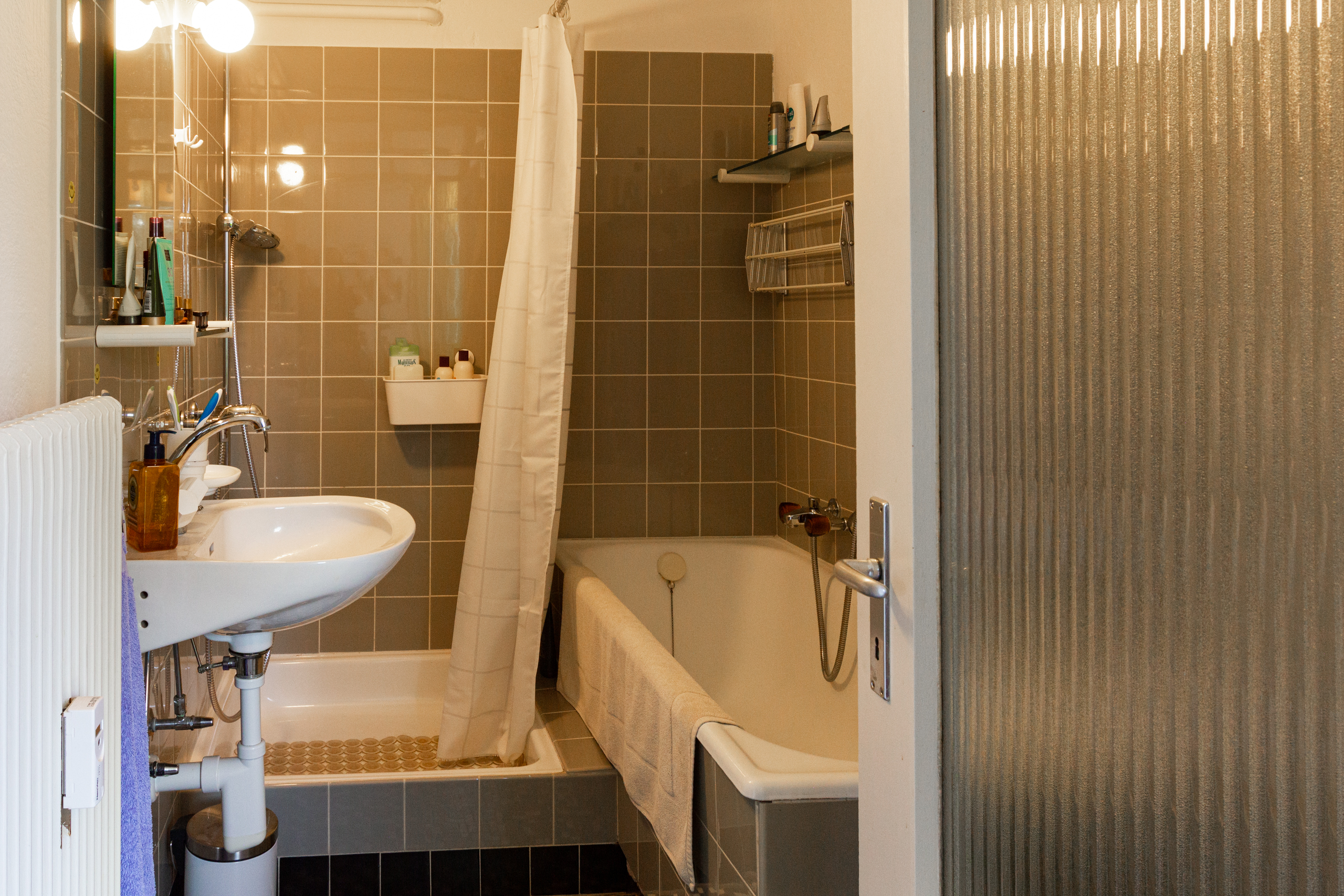 Kleines Badezimmer mit Badewanne und Waschbecken