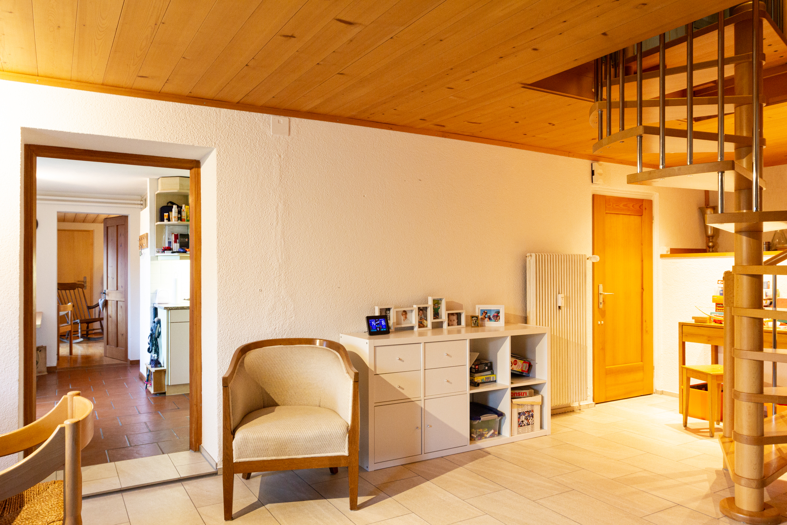 Wohnzimmer mit Holzdecke und Wendeltreppe