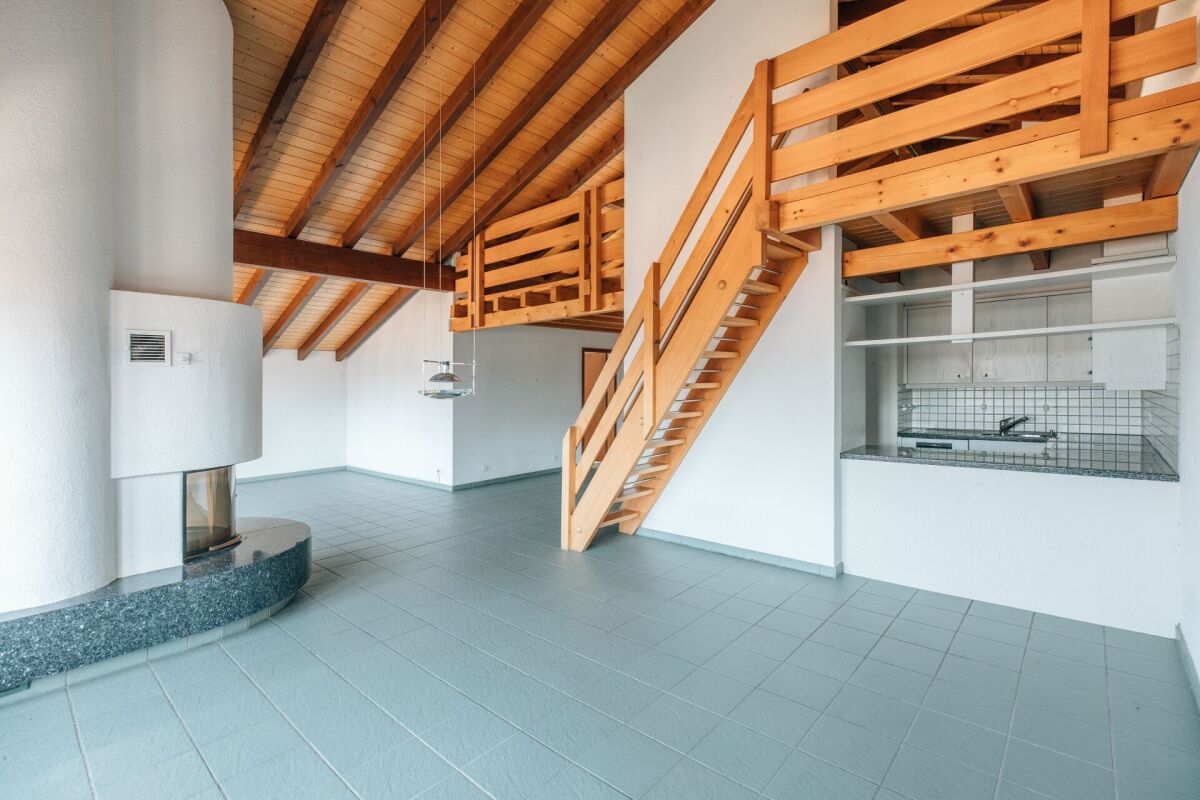 Heller Wohnraum mit Holzgalerie und Kamin