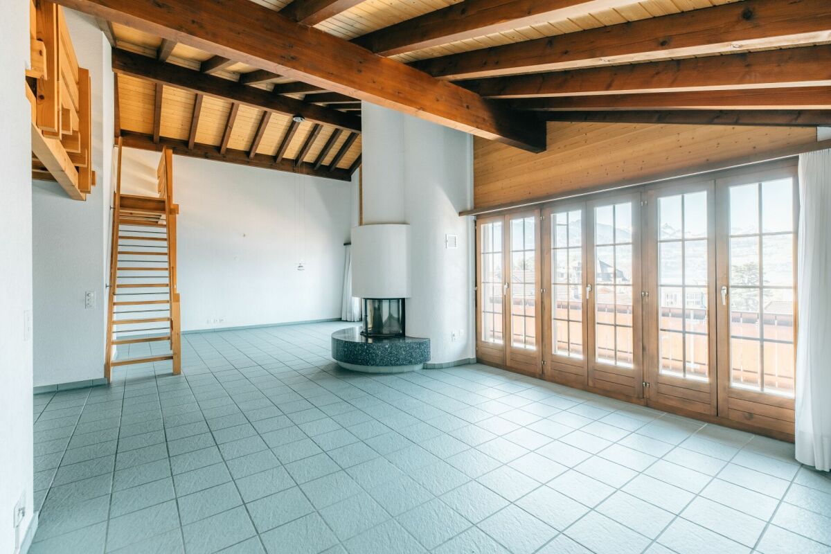Großer Wohnraum mit Kamin und Holzbalkendecke