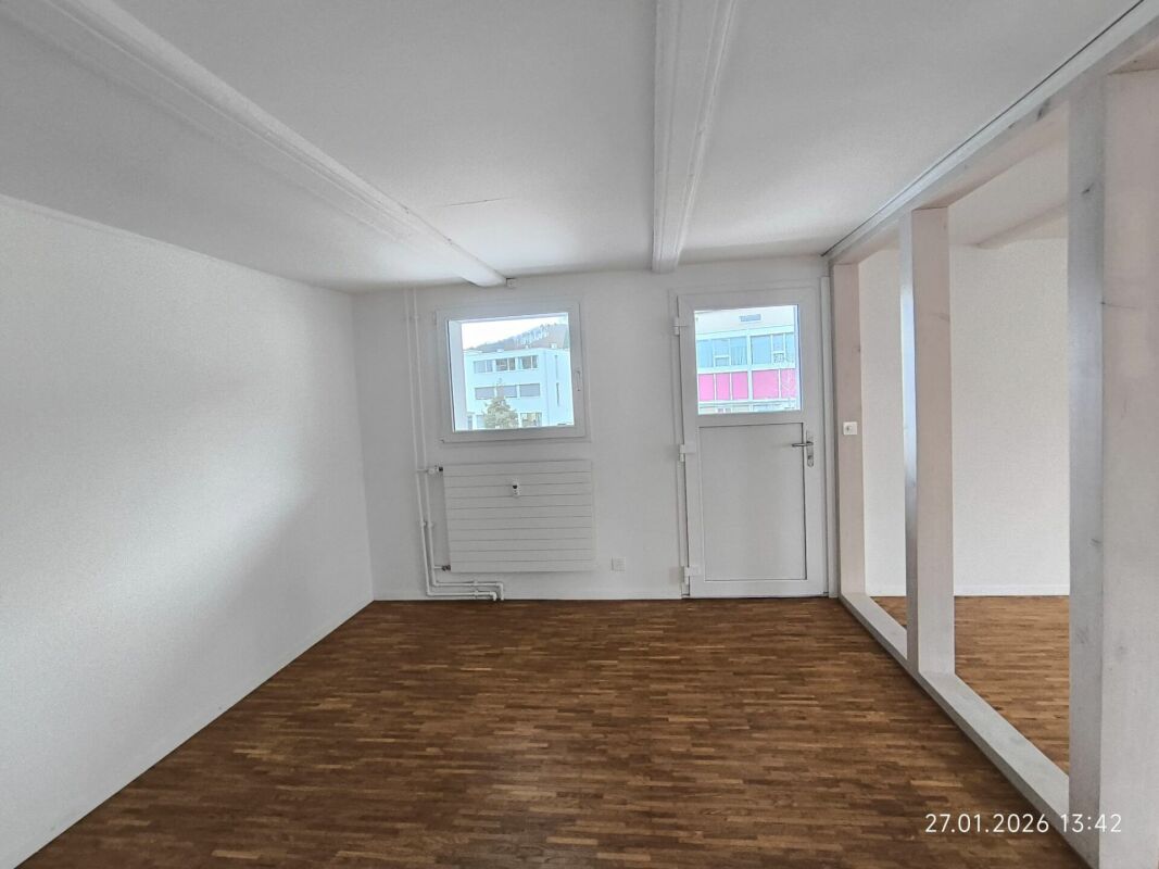 Leerer Innenraum mit Holzboden und weißem Ausbau