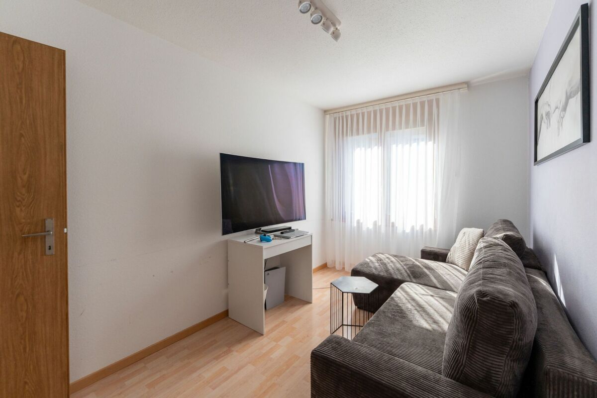 Helles Wohnzimmer mit Sofa und Fernseher