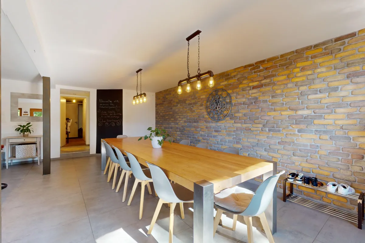 Esszimmer mit Ziegelwand und Holztisch