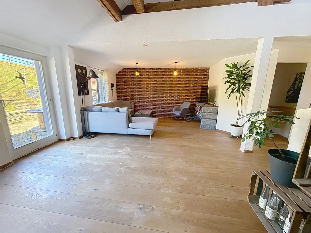 Wohnzimmer mit Backsteinwand und Holzboden