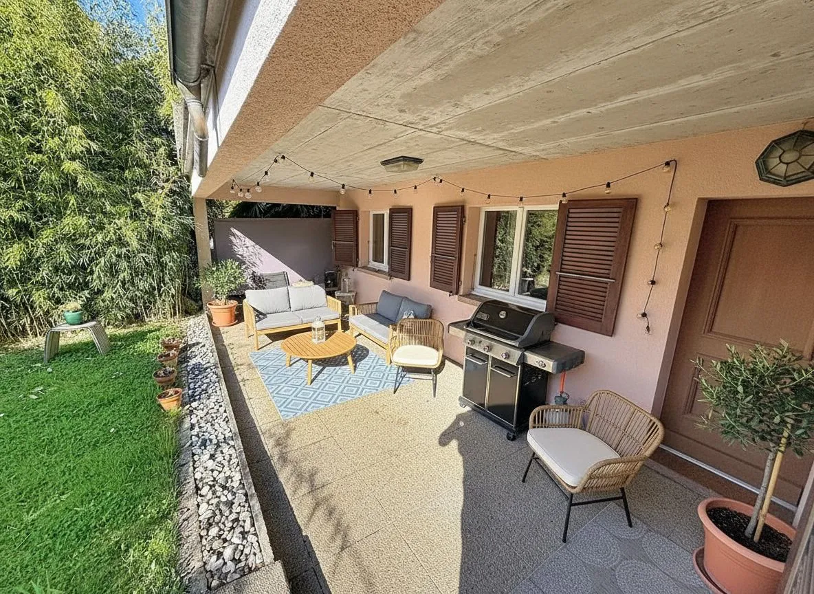 Überdachte Terrasse mit Sitzgruppe und Grill