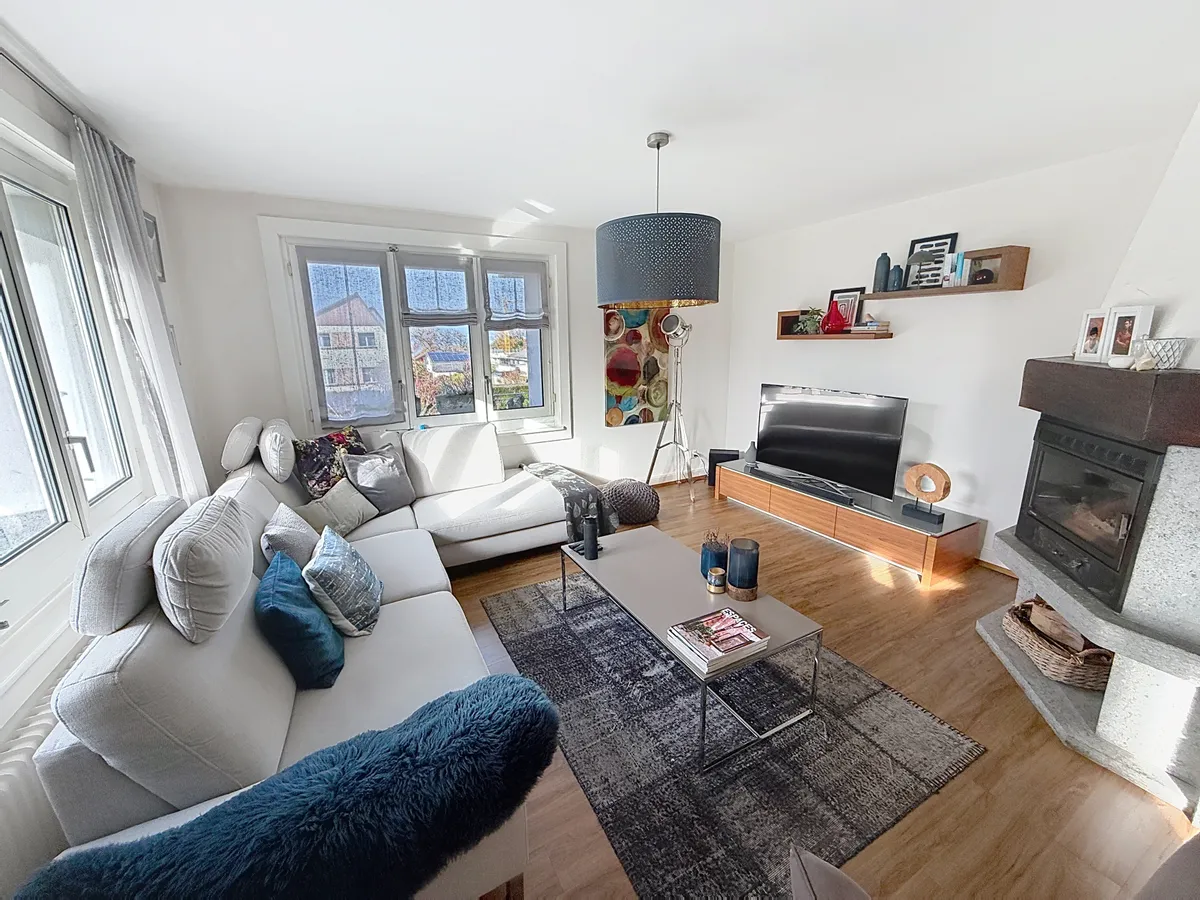 Helles Wohnzimmer mit Kamin und Ecksofa