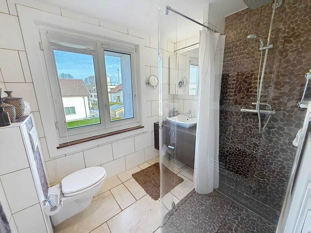 Badezimmer mit Fenster und gefliester Dusche
