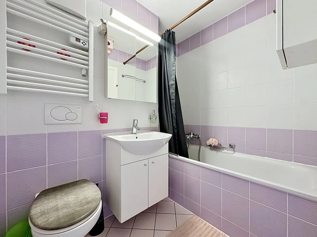 Kleines Badezimmer mit Badewanne und Waschbecken