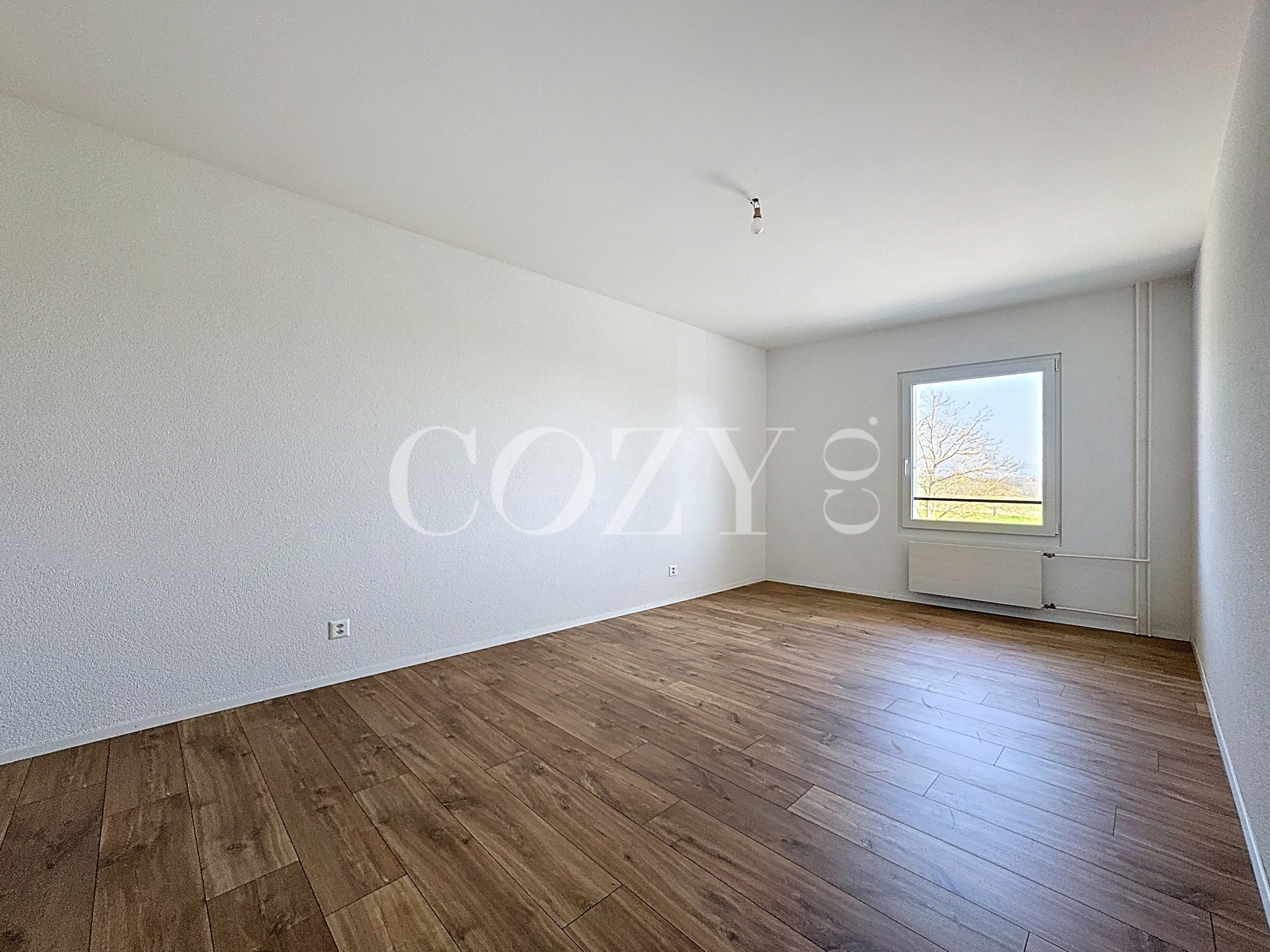 Leerer heller Raum mit Holzoptikboden