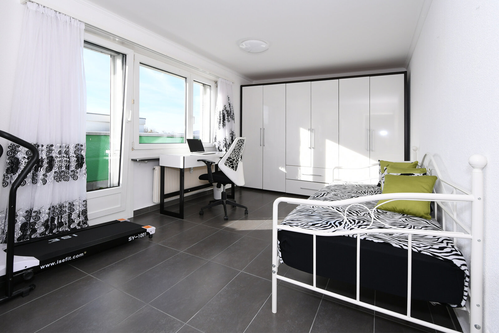 Helles Schlafzimmer mit Schreibtisch und Kleiderschrank