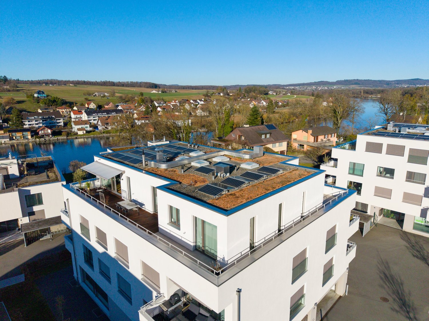 Moderne Wohnanlage am Wasser mit begrüntem Flachdach