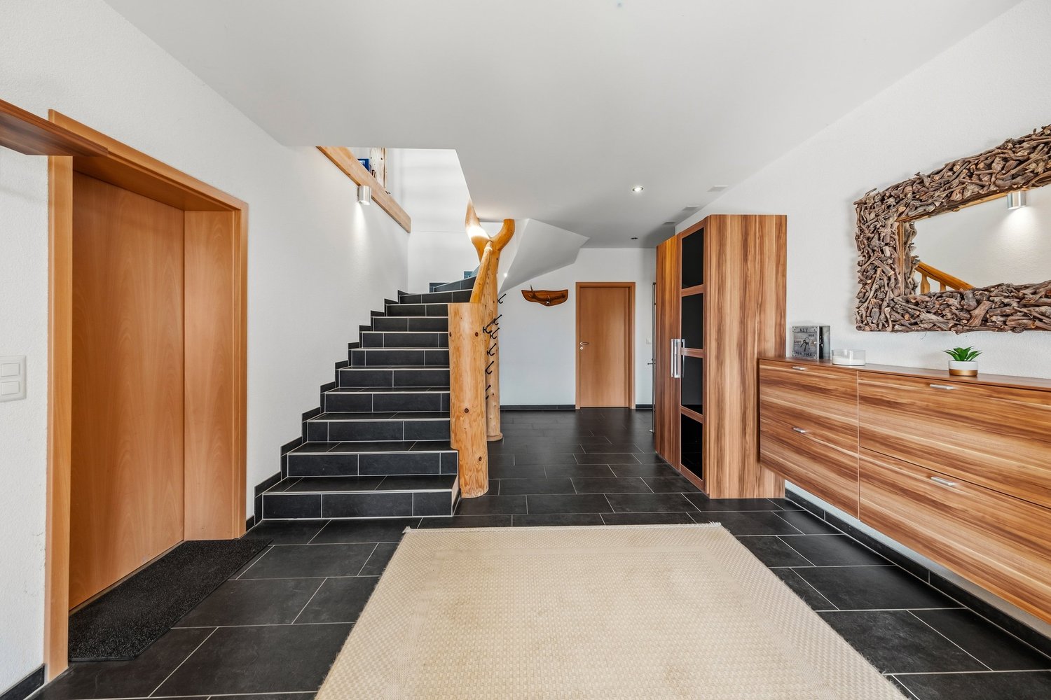 Moderner Eingangsbereich mit Treppe und Holzakzenten