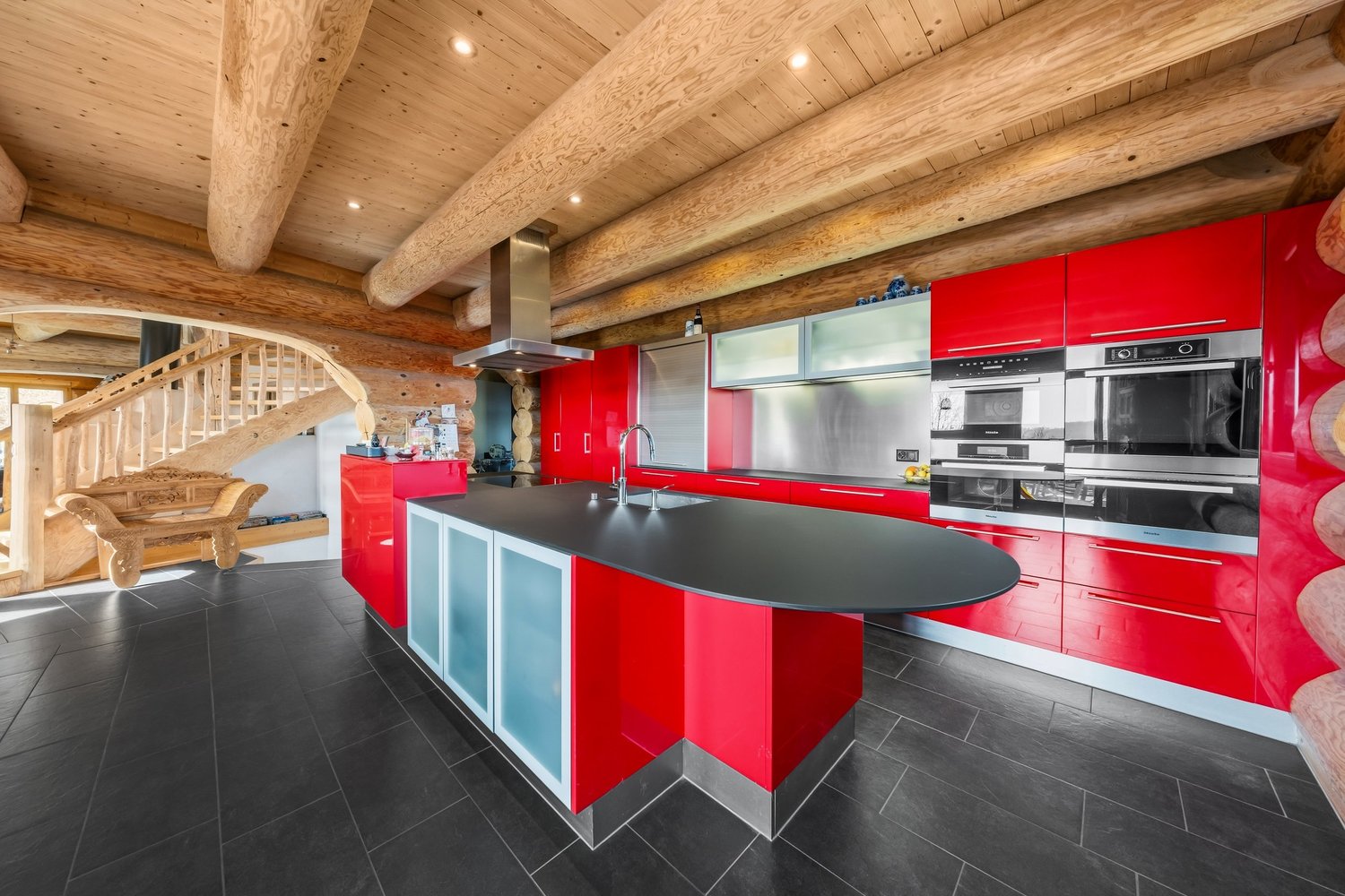 Moderne Landhausküche mit roter Hochglanzfront und Holzdecke