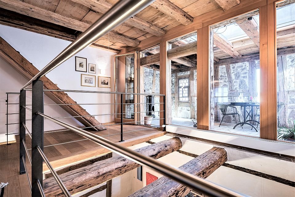 Rustikaler Innenraum mit sichtbaren Holzbalken und Galerie