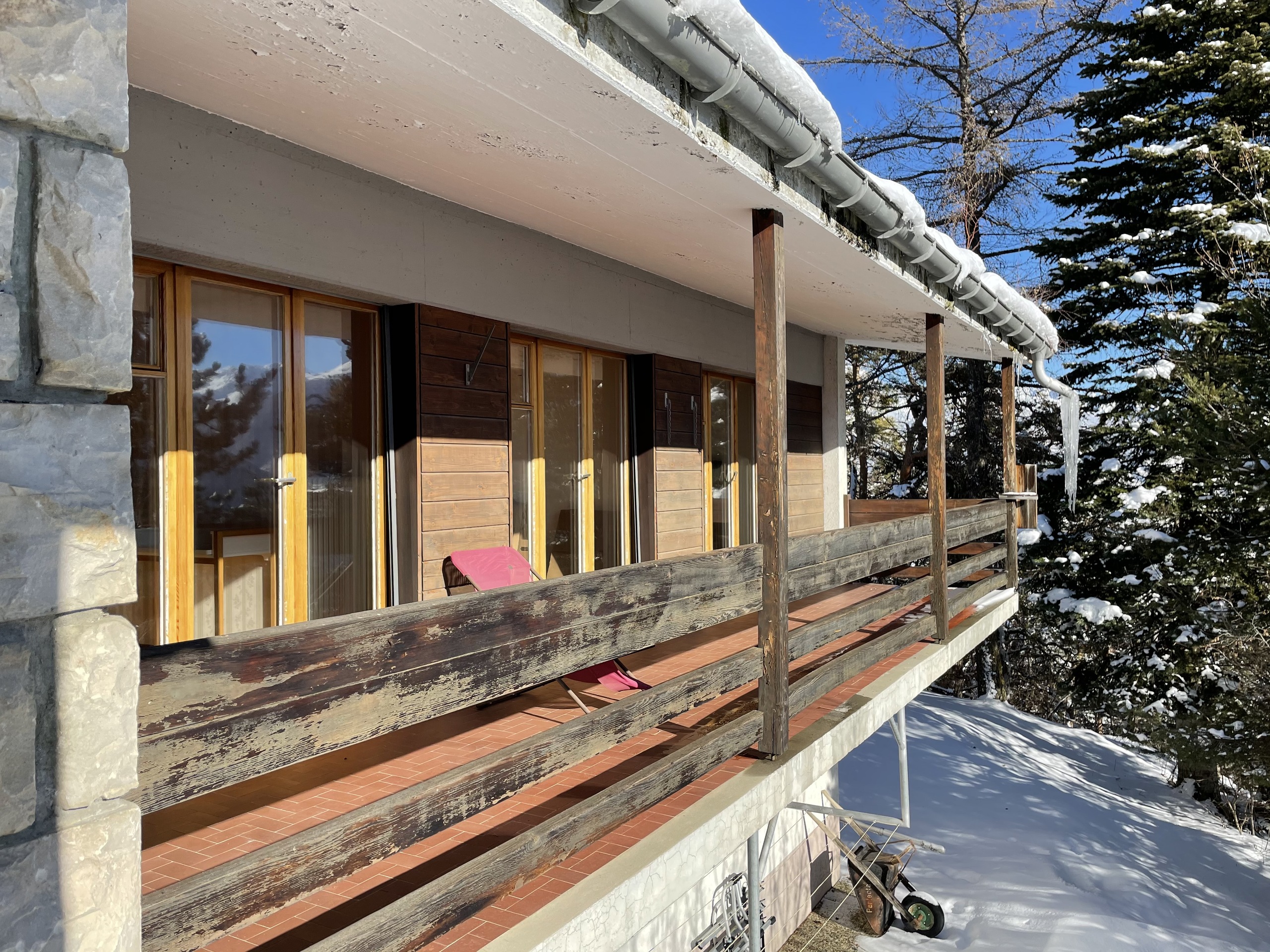 Schneebedeckter Balkon mit Holzgeländer