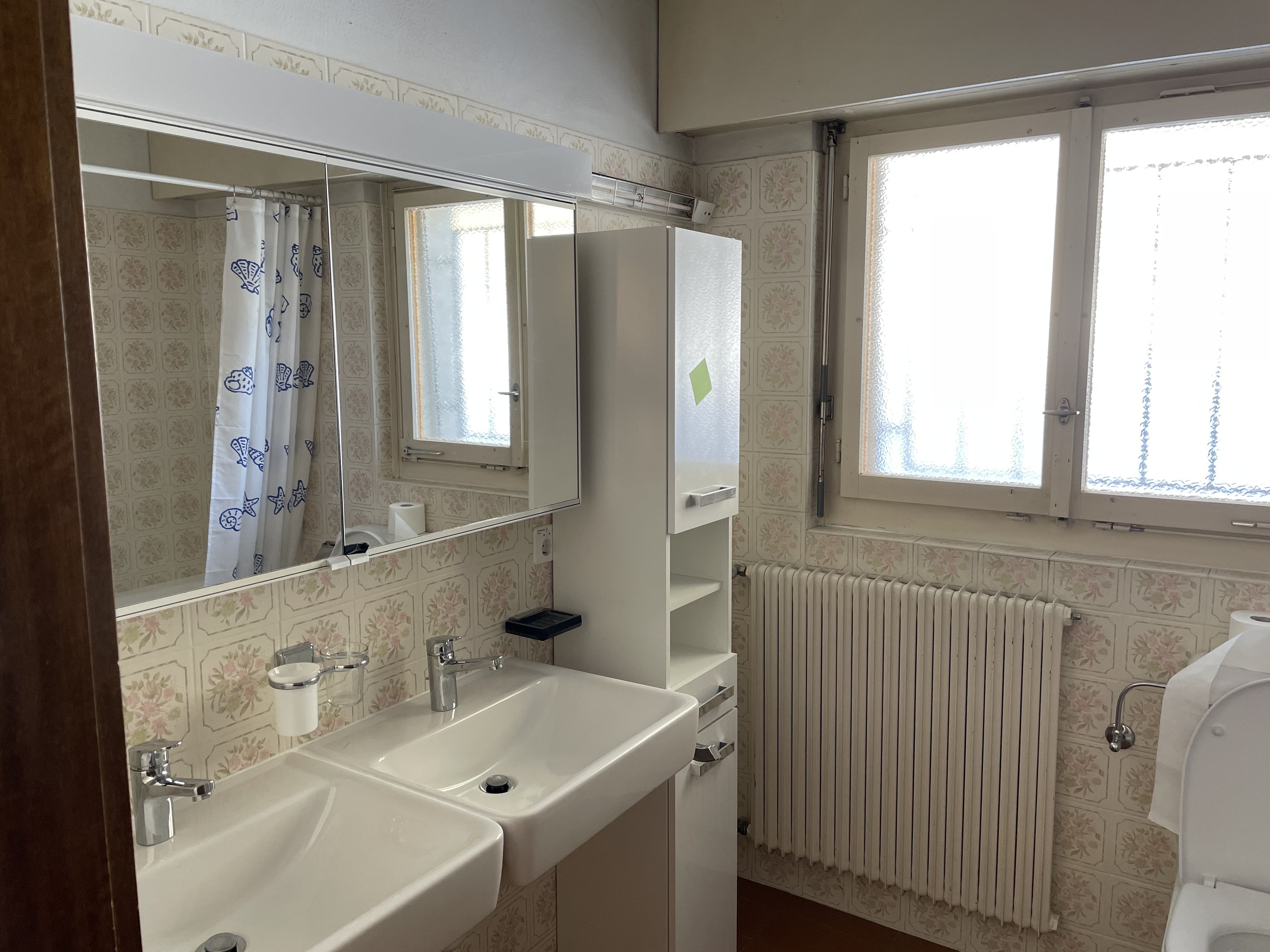 Badezimmer mit Doppelwaschbecken und Blumenfliesen