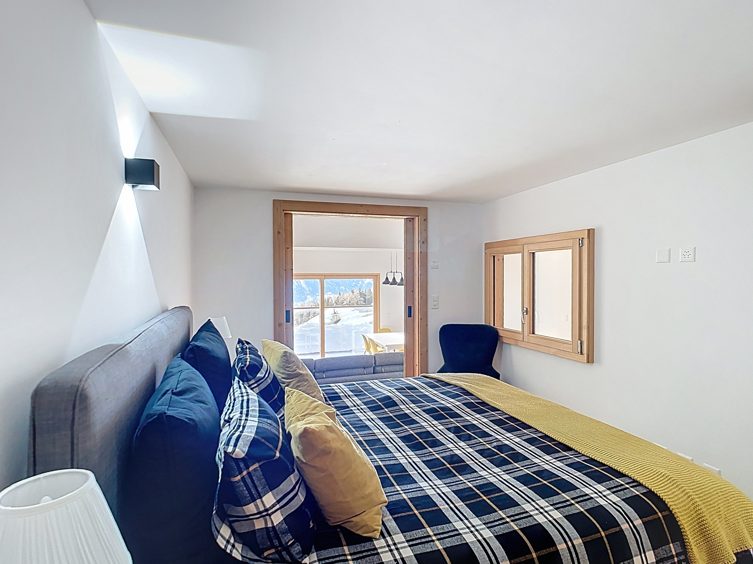 Gemütliches Schlafzimmer mit Tageslicht und Ausblick ins Winterpanorama