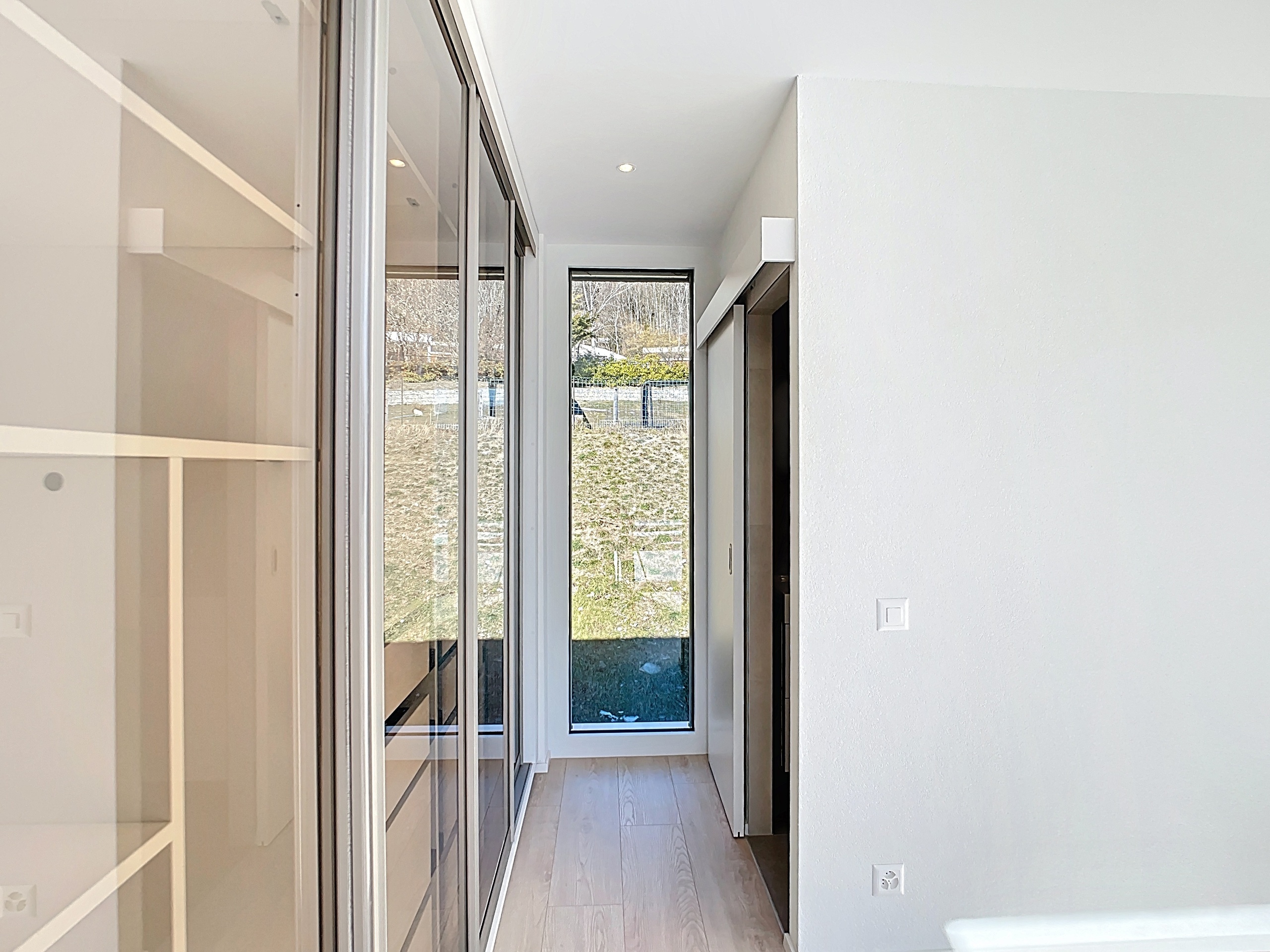 Heller Flur mit großem Fenster und Glastüren