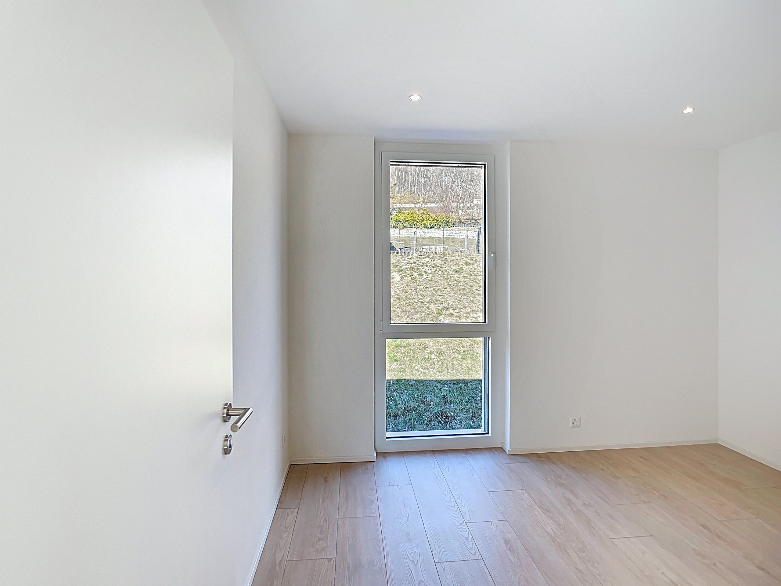 Heller leerer Raum mit großem schmalen Fenster