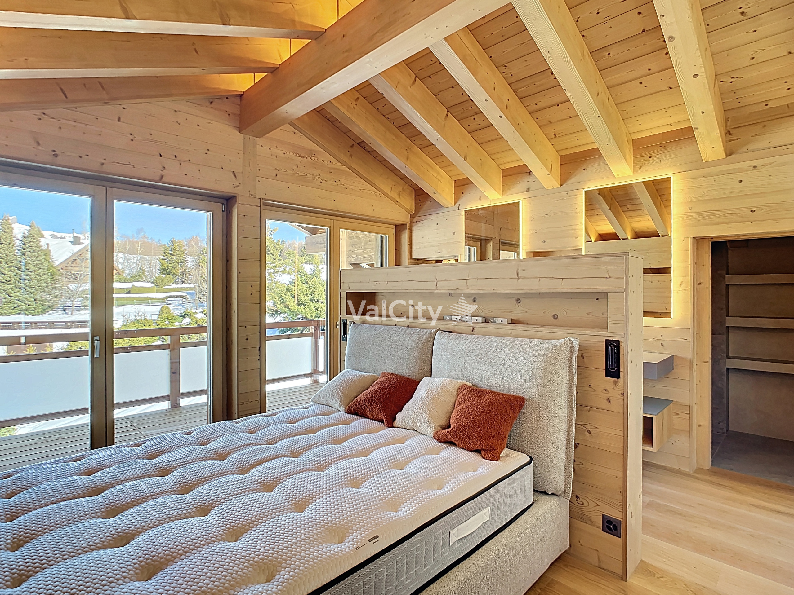 Gemütliches Holz-Schlafzimmer mit Balkonblick